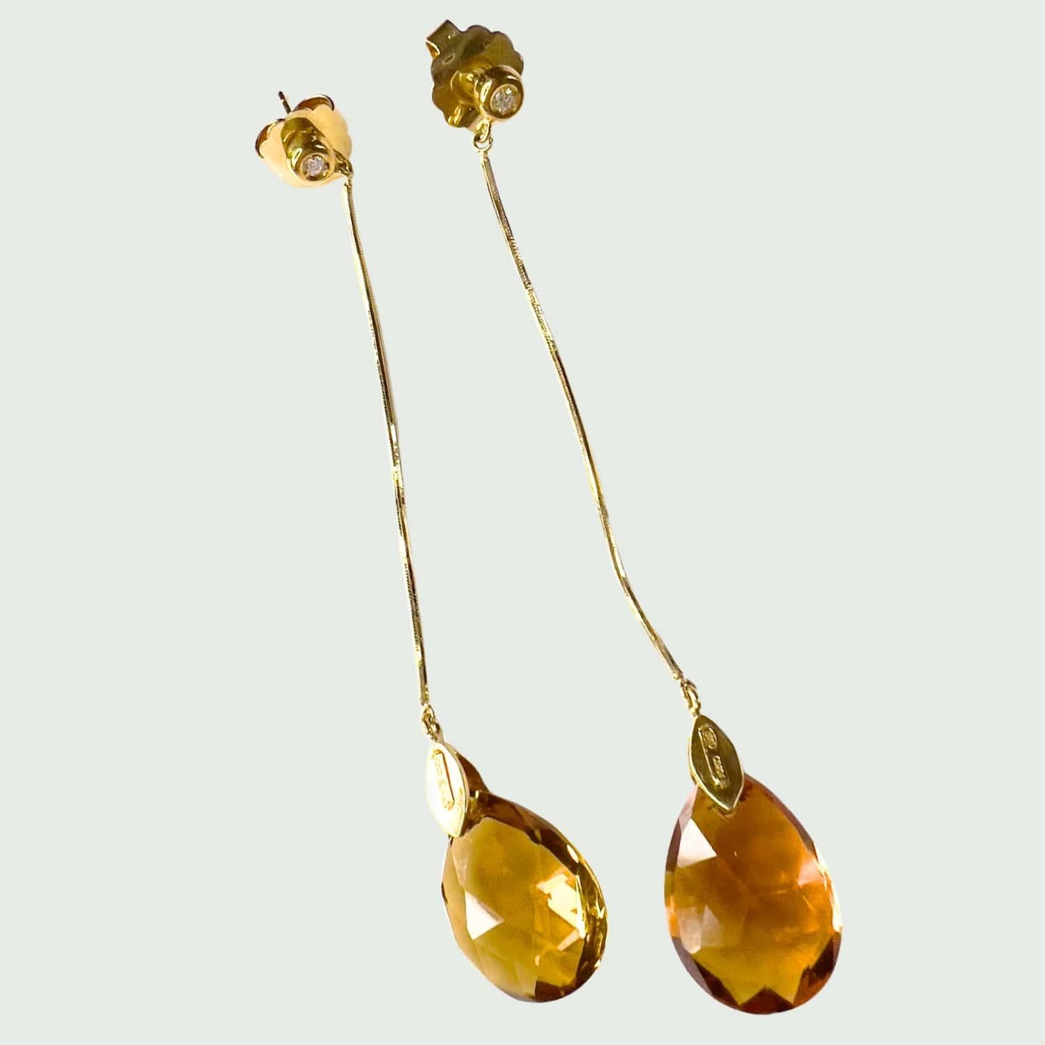 These modern earrings from the 20th Century are crafted in 18K yellow gold and feature brilliant-cut Diamonds totaling 0.08 carats, along with citrine drops. They have a combined weight of 8.50 grams and measure 8.5 cm in length. The Diamonds are of