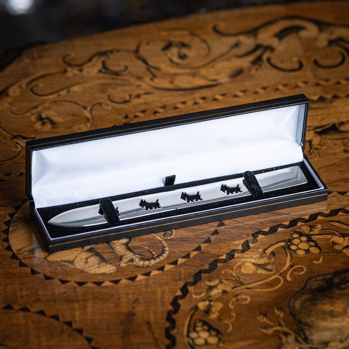 Modern 20th Century French solid silver letter opener by Cartier, crafted in a sleek, flat design with a sharp pointed end. Embellished with four stamp cut schnauzer dog motifs. Presented in a wonderful box. Marked on the reverse 
