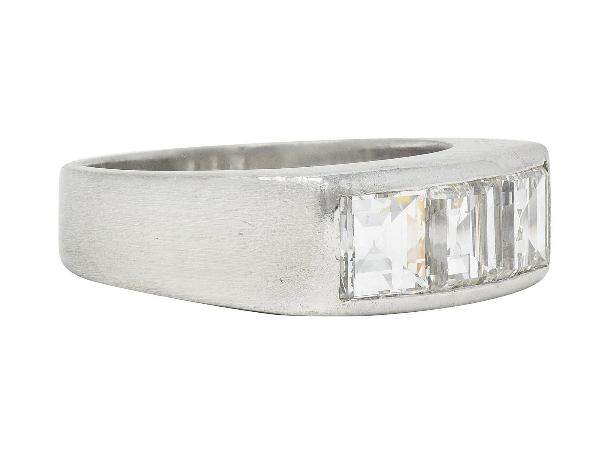 Centering three square step cut diamonds set east to west in channel
Weighing approximately 2.82 carats total - F/G color with VS2 clarity
Flanked by sloping shoulders 
With matte finish 
Tested with partial stamps for platinum
Circa: 1950s
Ring