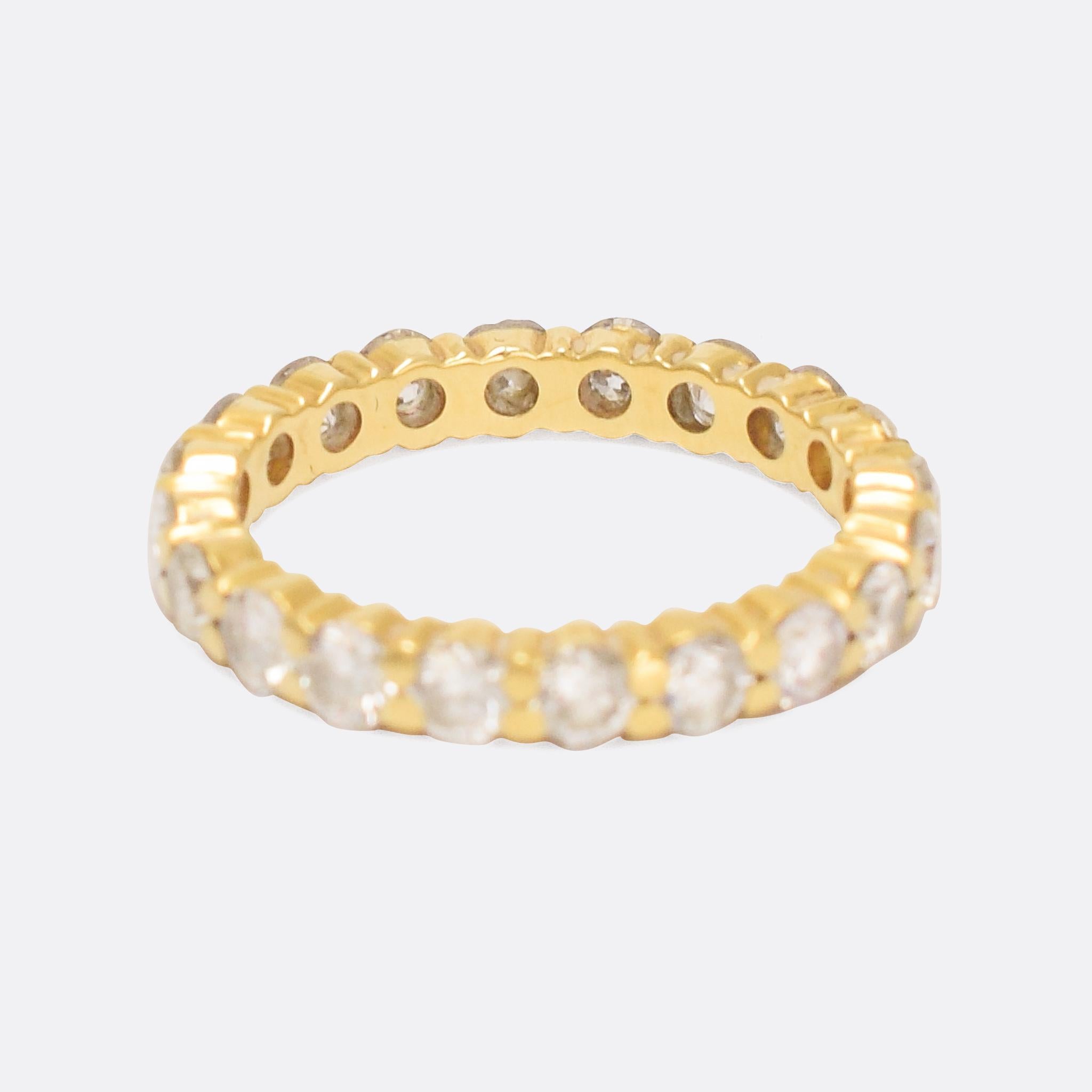 Superb contemporary eternity ring set with over 2 carats of bright brilliant cut diamonds. The stones rest in tension settings, and the ring is constructed in 18k yellow gold throughout. It's a good size (5.5 US), particularly well made, and looks