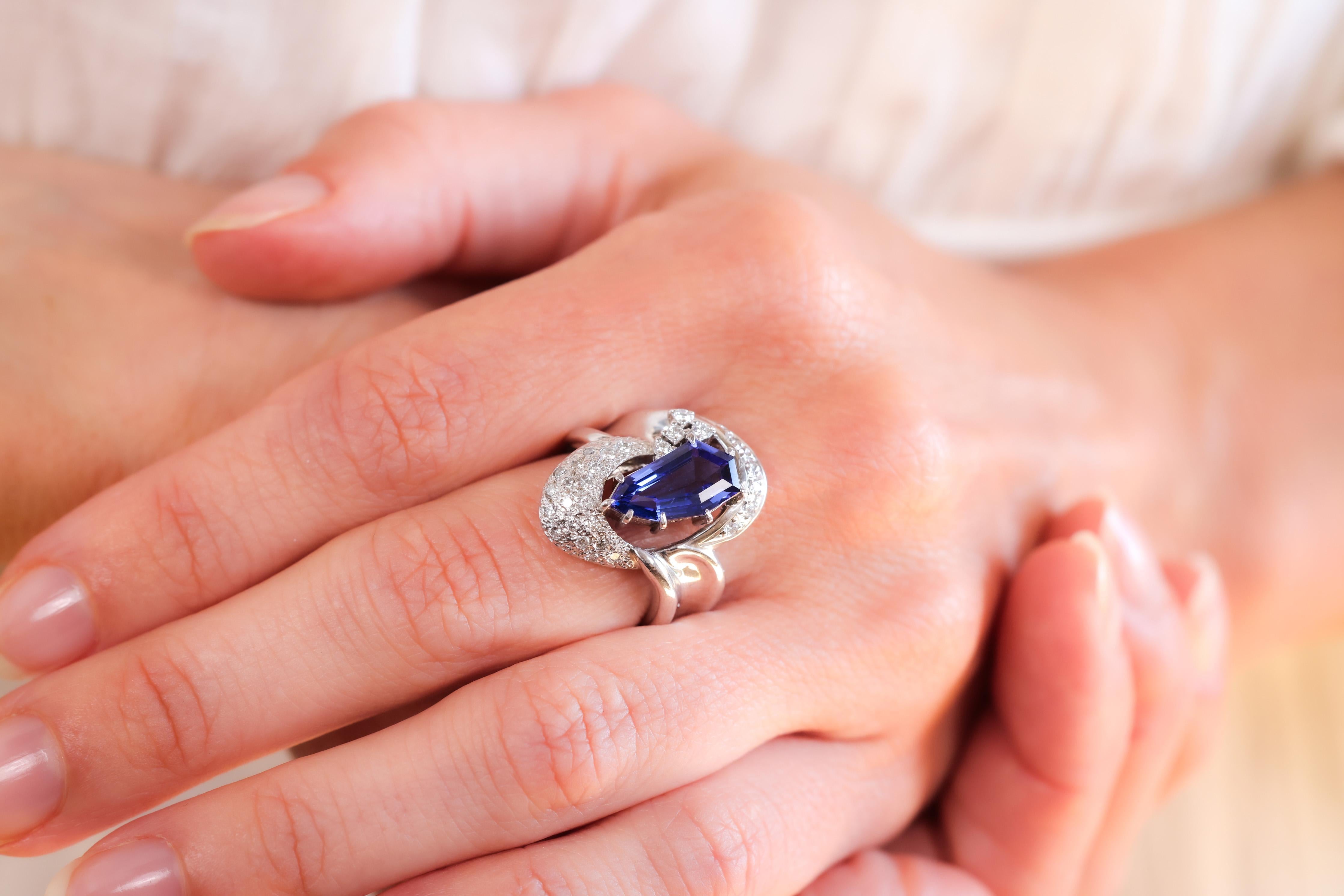 Center Stone: Purple Tanzanite
Cut: Irregular Coffin Step Cut
Weight: 2.31 Carat
Accent Stone: 28 Diamonds
Cut: Round Brilliant 
Weight: 0.39 Carats
Color: G-H
Clarity: VVS
Metal: Platinum
Era: Modern
Circa: 2000's
Hallmarks: PT900 Purity Mark,