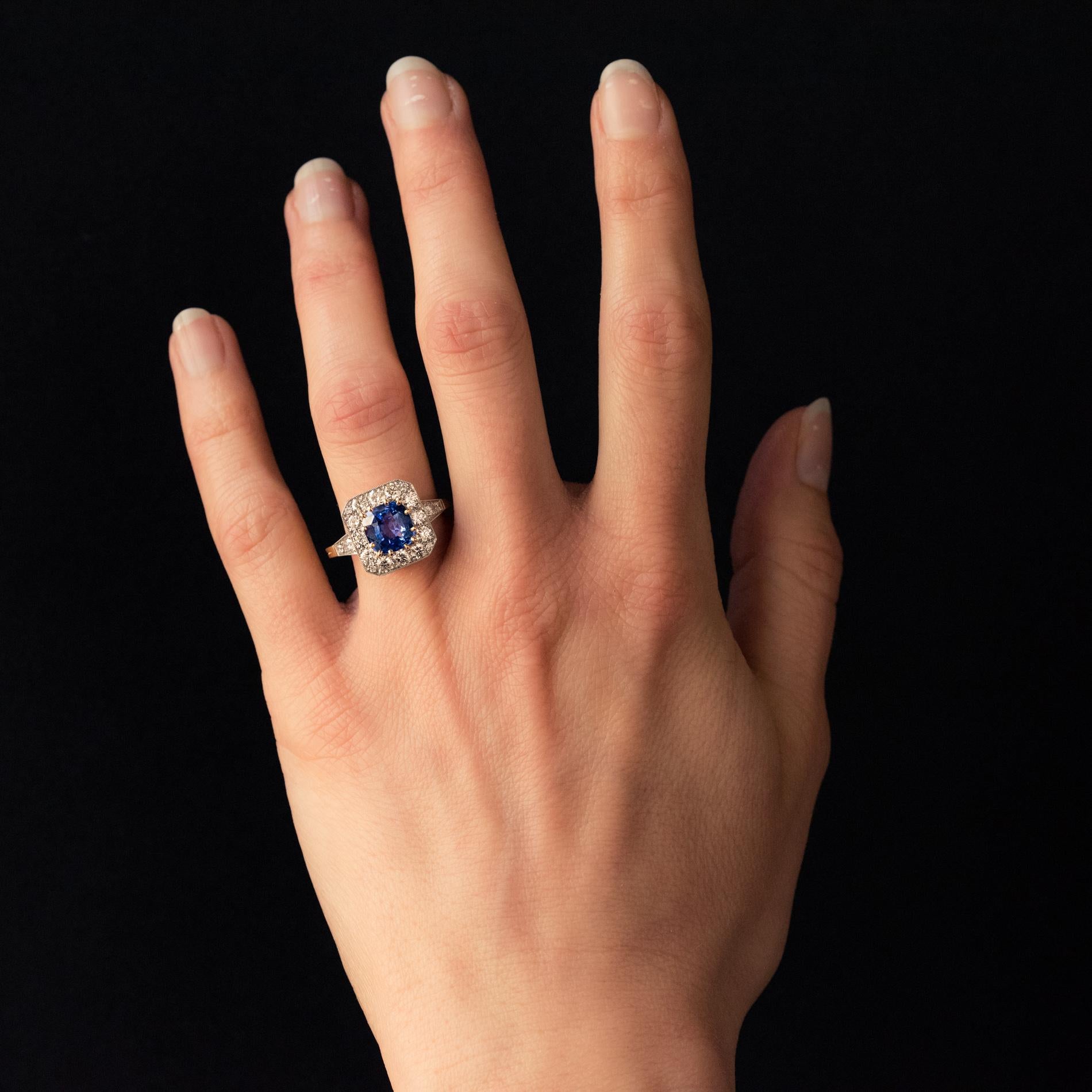 Ring in 18 karat yellow gold, and platinum, eagle's head and dog's head hallmarks.
It is set in the center of a cushion-cut sapphire on a square decor set with 16 modern brilliant-cut diamonds. On both sides, on the start of the ring are set 2 x 2