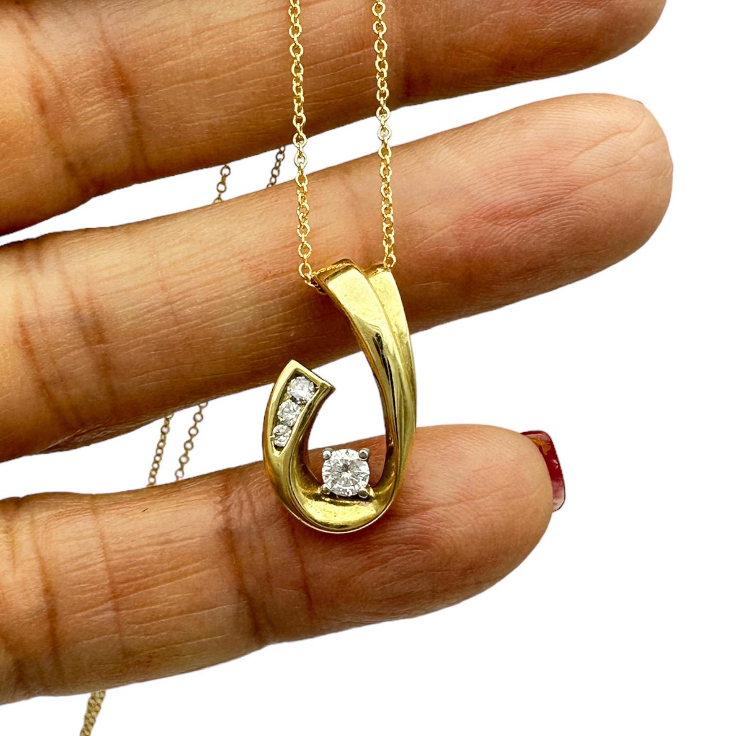 Der stilisierte Anhänger besteht aus einem runden Brillanten, der von drei in drei Kanälen gefassten Diamanten akzentuiert wird. Der Anhänger misst 1 Zoll Länge und 1/2 Zoll Breite und ist stabil mit einer 10 mm breiten Bügelöffnung für jede