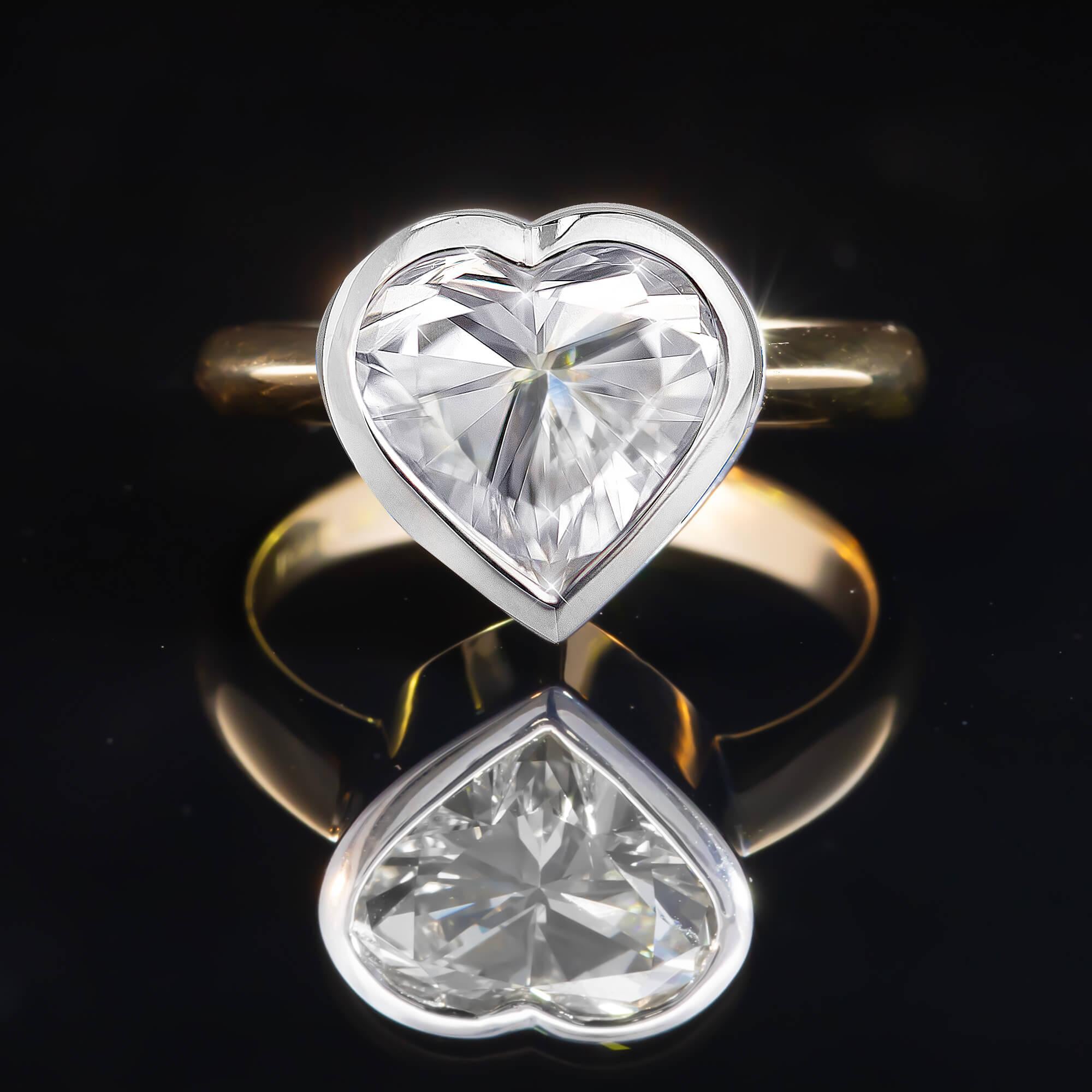 Un precioso y moderno anillo de diamantes elaborado en oro de 18 quilates bicolor, con un diamante talla corazón de 3,00 ct engarzado en un bisel. Un diseño clásico y atemporal para marcar la diferencia.

Diamante: Una talla corazón, color K,