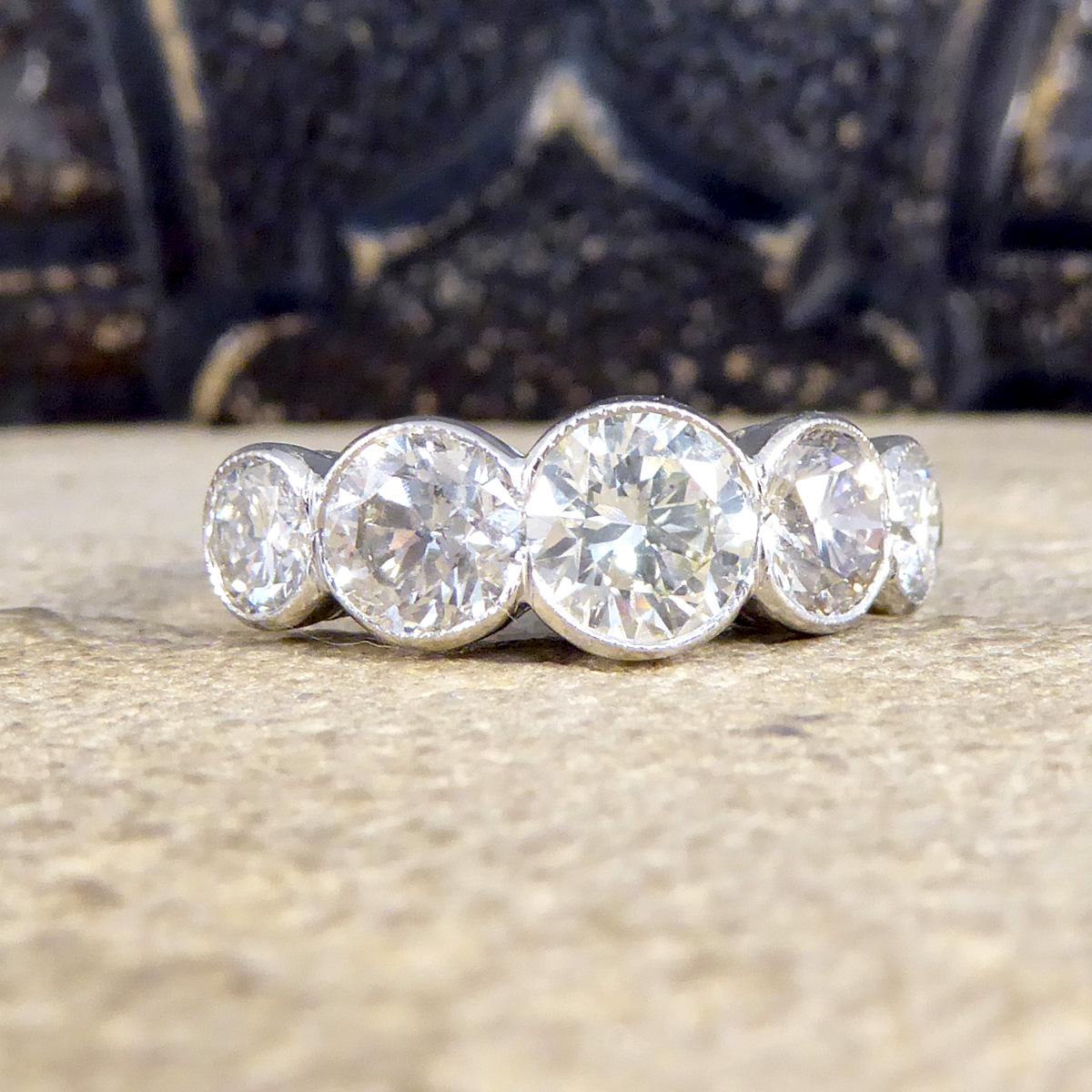Ein aufsehenerregender Diamantring mit fünf Steinen, gefasst in Platin mit einer leichten Millegrain-Detailierung. Dieser Ring ist zeitgenössisch und wurde mit fünf Diamanten im Brillantschliff gefertigt, die alle in Kragenfassungen gefasst sind, so