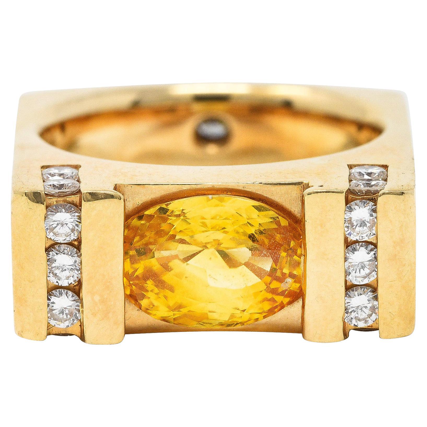 Cushion shaped ring is designed with polished gold bar motifs

Featuring a bar set mixed oval cut sapphire weighing in total approximately 2.90 carats

Transparent and strongly yellow in color with orange saturation towards ends

Flanked by channel