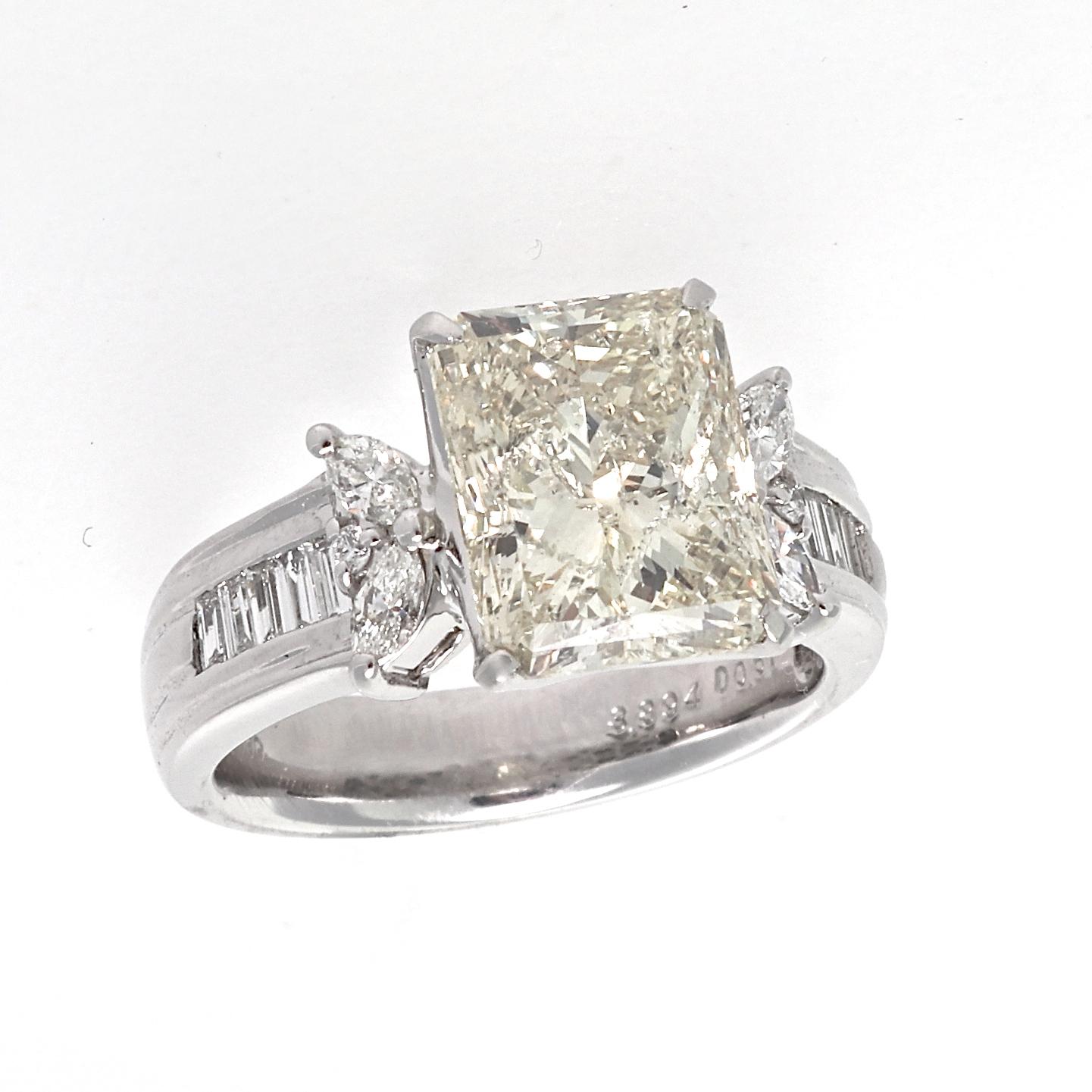 Deriving tradition into modern design is a sentiment that lasts a lifetime. Featuring a  3.89 carat radiant cut diamond that illuminates light yellow natural color and is slightly included. Exquisitely accented by numerous near colorless round,