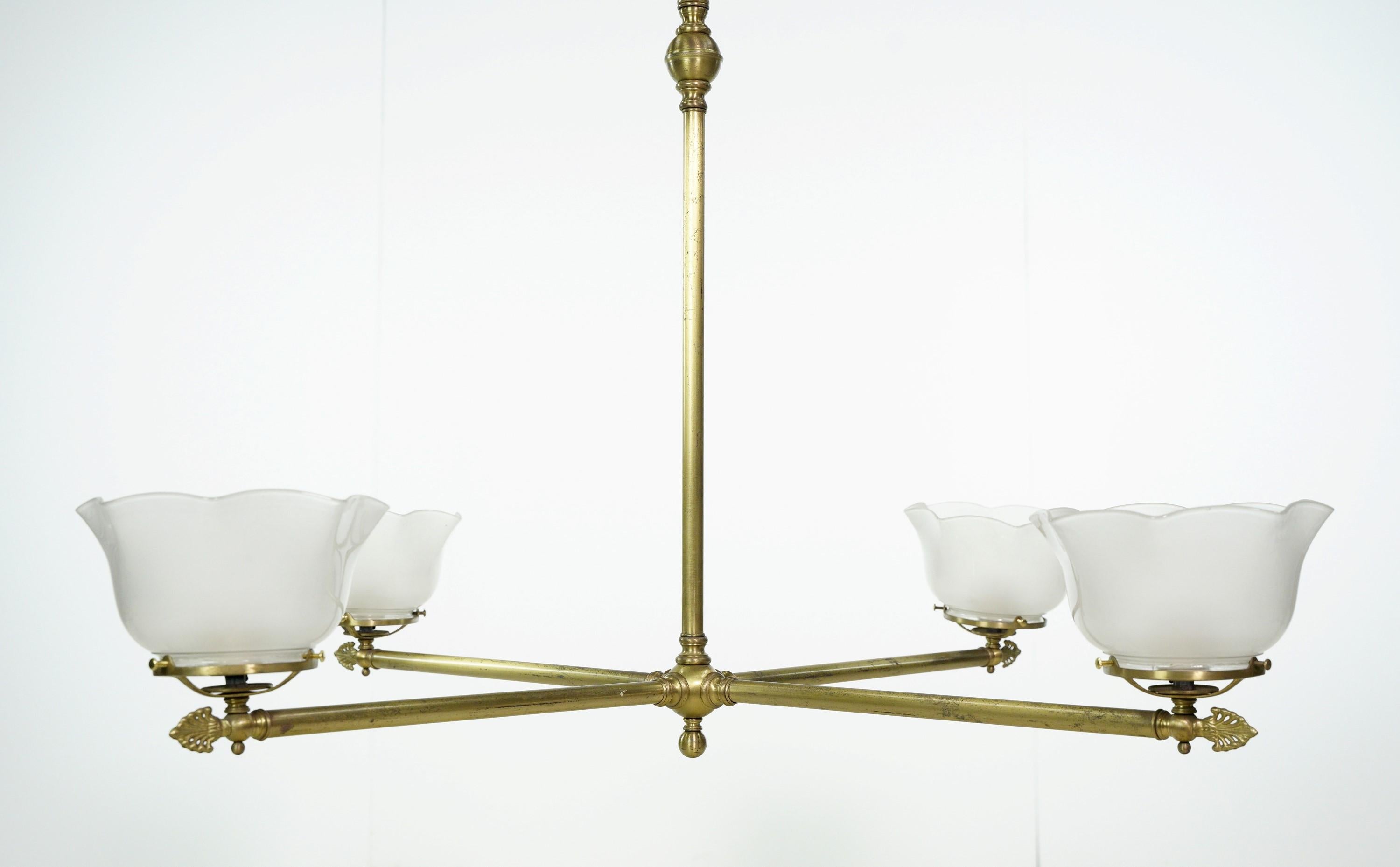 This Modern style brass plated steel four arm ruffled glass shades chandelier showcases modern elegance. The brass plated steel frame creates a sleek and stylish look, while the ruffled glass shades add a touch of sophistication. This chandelier