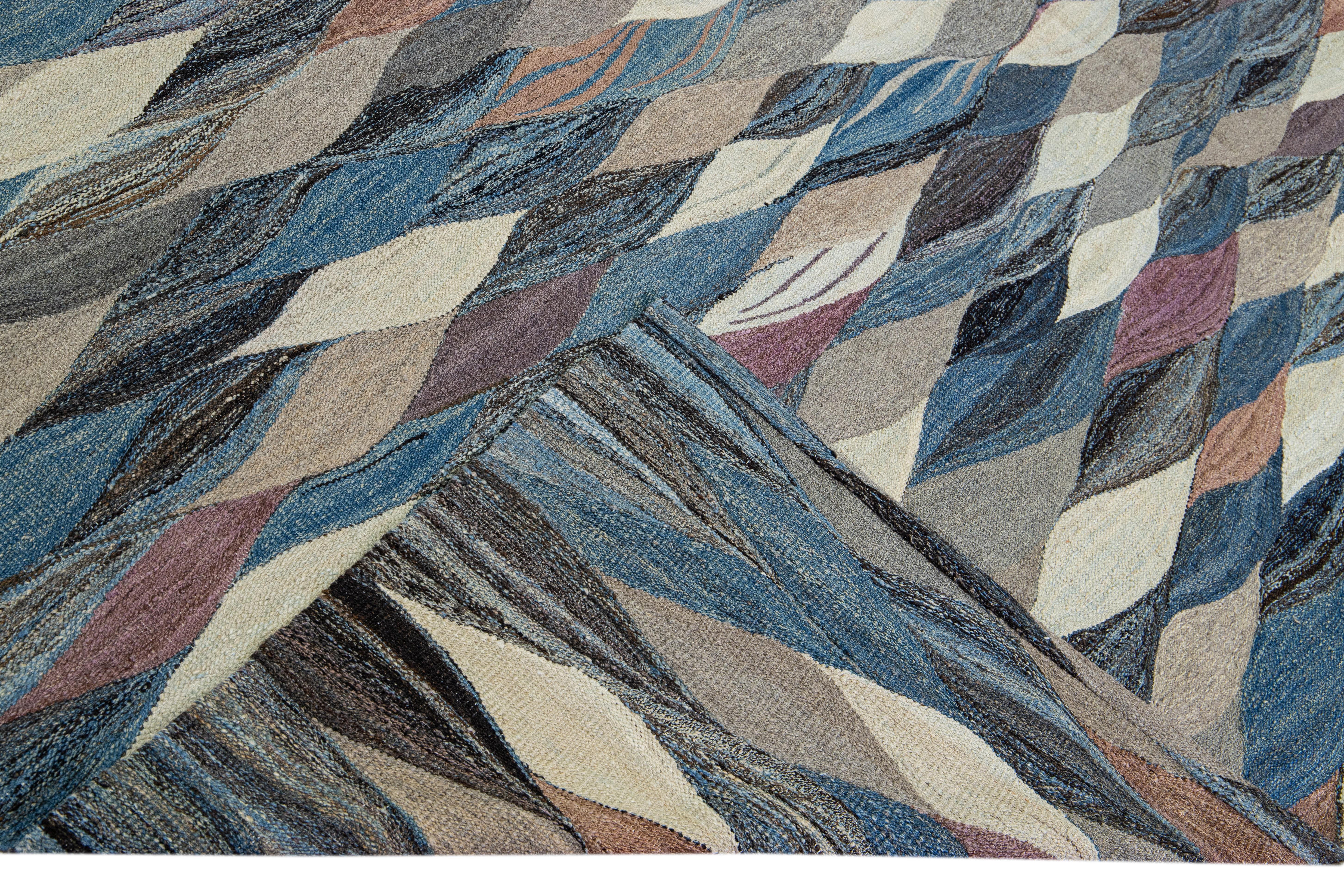 Magnifique tapis Kilim moderne en laine tissé à plat, fait à la main, avec un champ bleu. Ce tapis Kilim a des accents multicolores dans un magnifique design expressionniste abstrait.

Ce tapis mesure : 11'.8