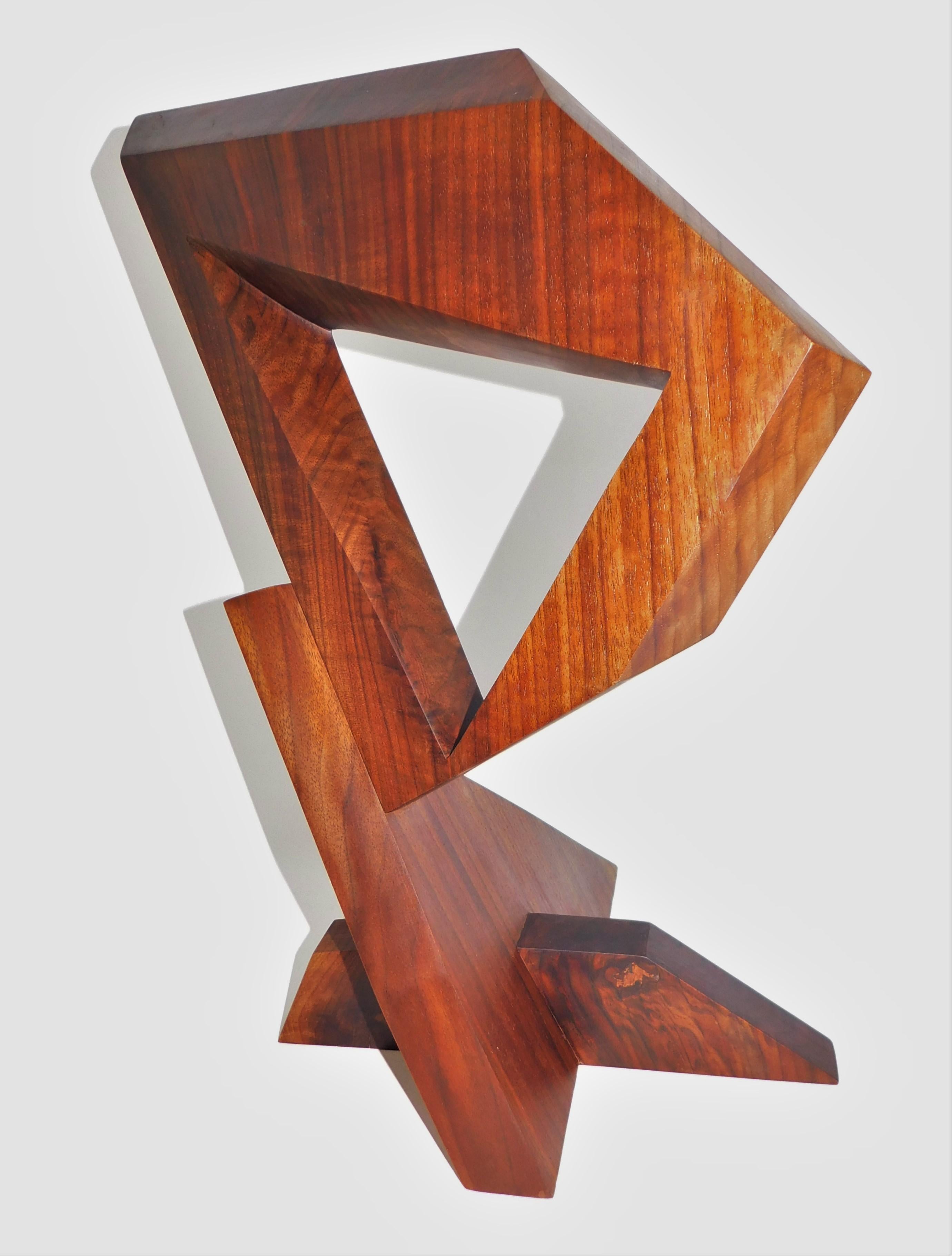 This contemporary abstract wooden sculpture is by Czeslaw Budny in constructivist style circa 2022. This unique sculpture is made of recycled walnut. Budny utilizes the simplicity of shapes such as the cube, circle and triangle to create modern