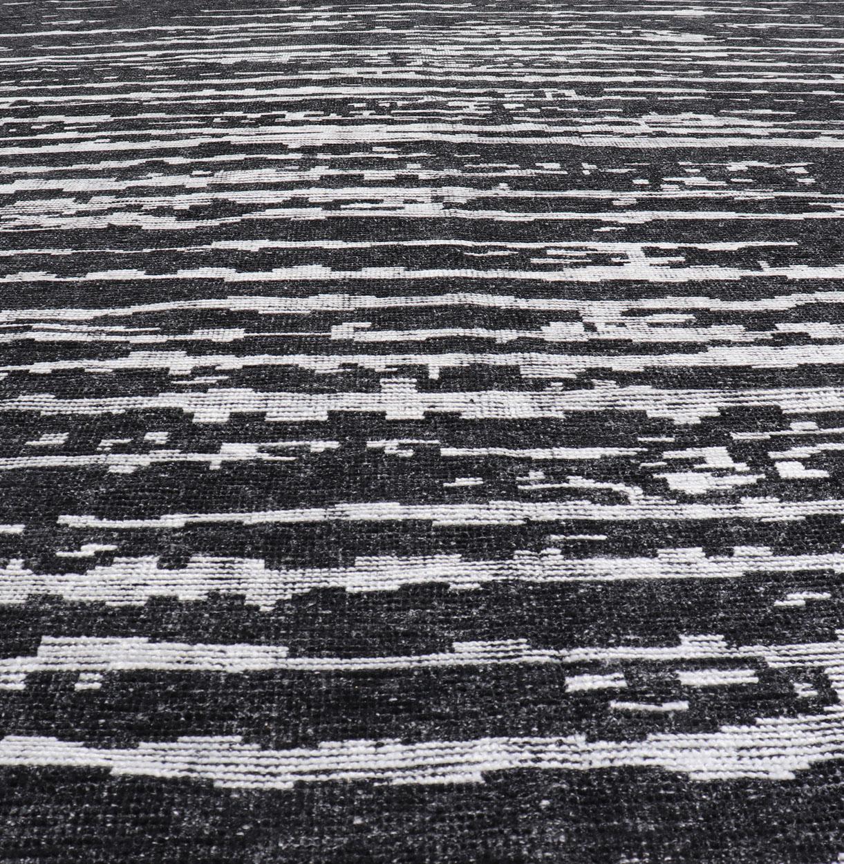 Measures 9'9 x 15'0 

The field is an asymmetrical blend of black and white. The piece features two different pile levels, giving this rug texture and character. This wonderful abstract carpet is a wonderful addition to any modern interior.