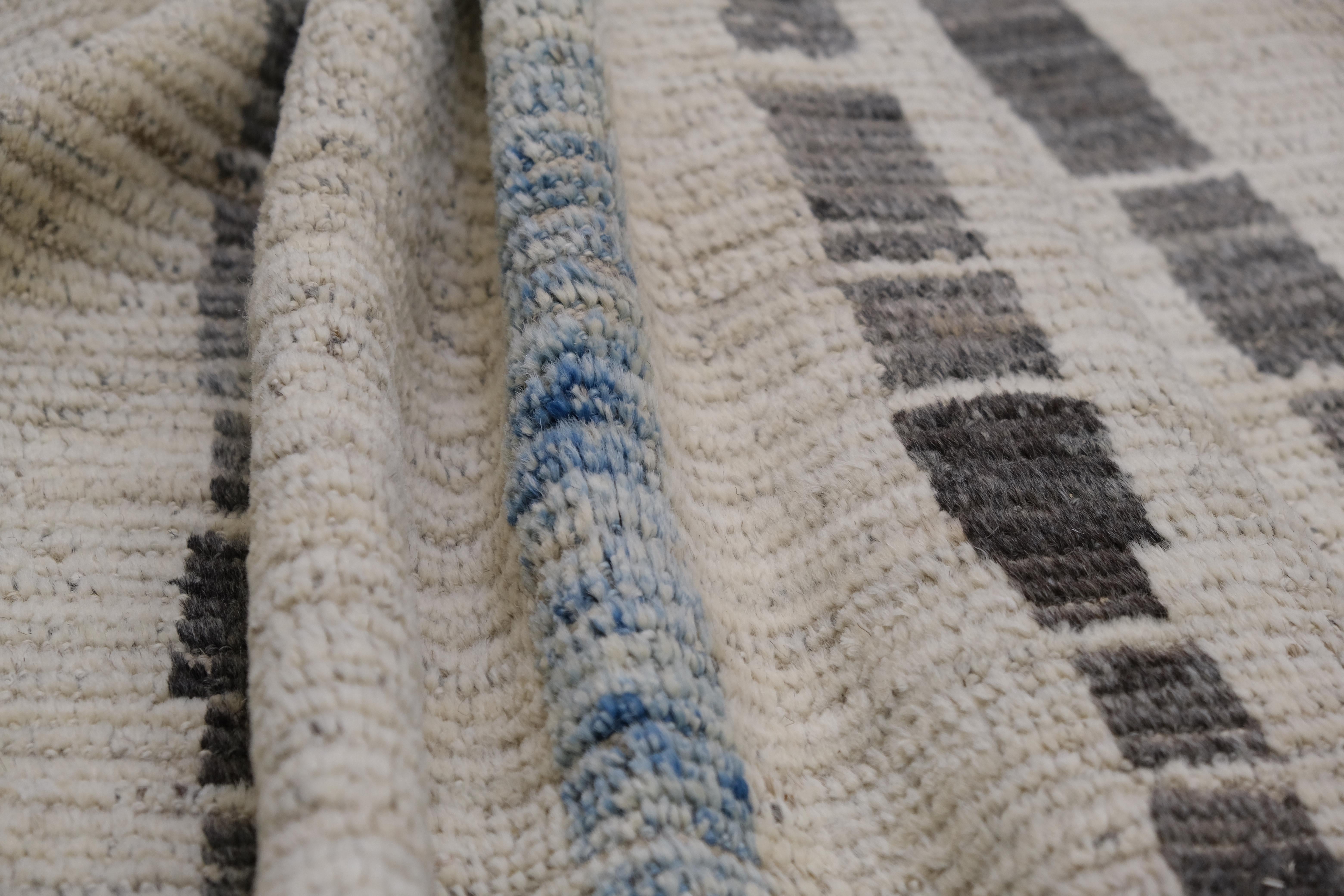 Dieser handgeknüpfte Wollteppich aus Afghanistan ist ein Beispiel für die perfekte Verschmelzung von traditioneller Handwerkskunst und zeitgenössischem Design. Der Teppich mit seinem komplizierten abstrakten geometrischen Muster ist in erdigen