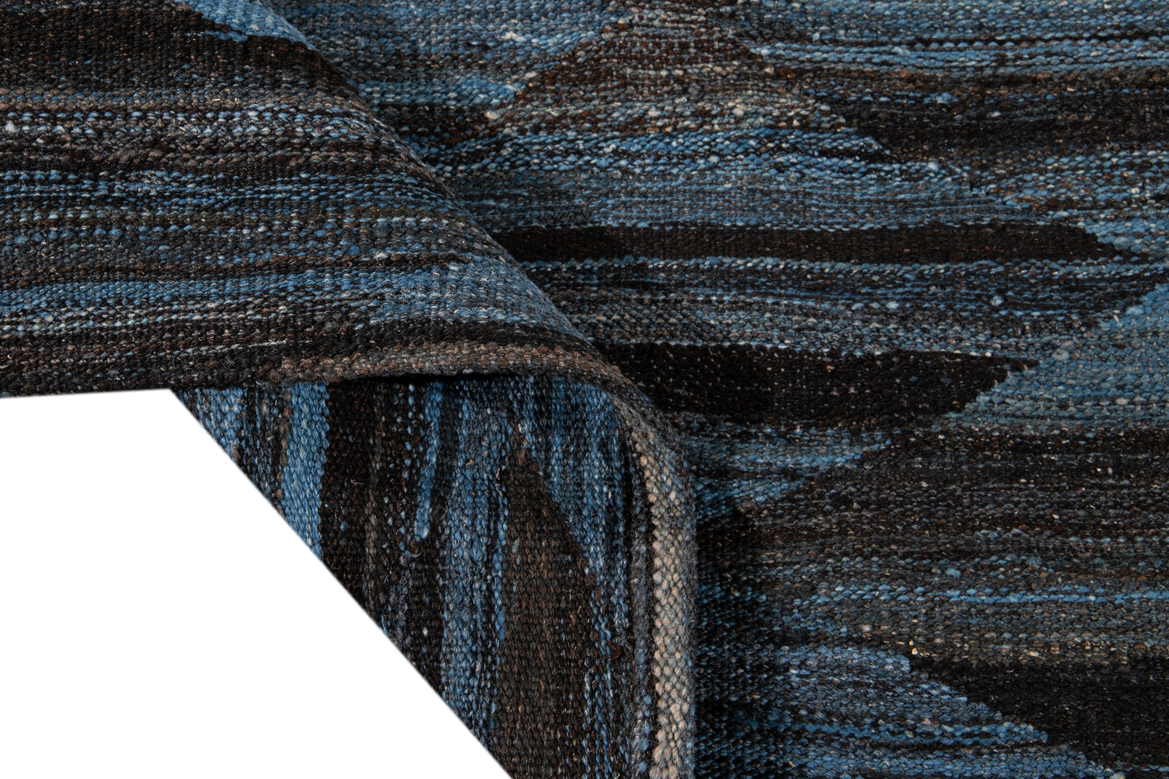 Magnifique tapis Kilim moderne en laine tissé à plat, fait main, avec un champ brun. Ce tapis Kilim a des accents d'ivoire et de bleu dans un magnifique design expressionniste abstrait.

Ce tapis mesure : 8'10
