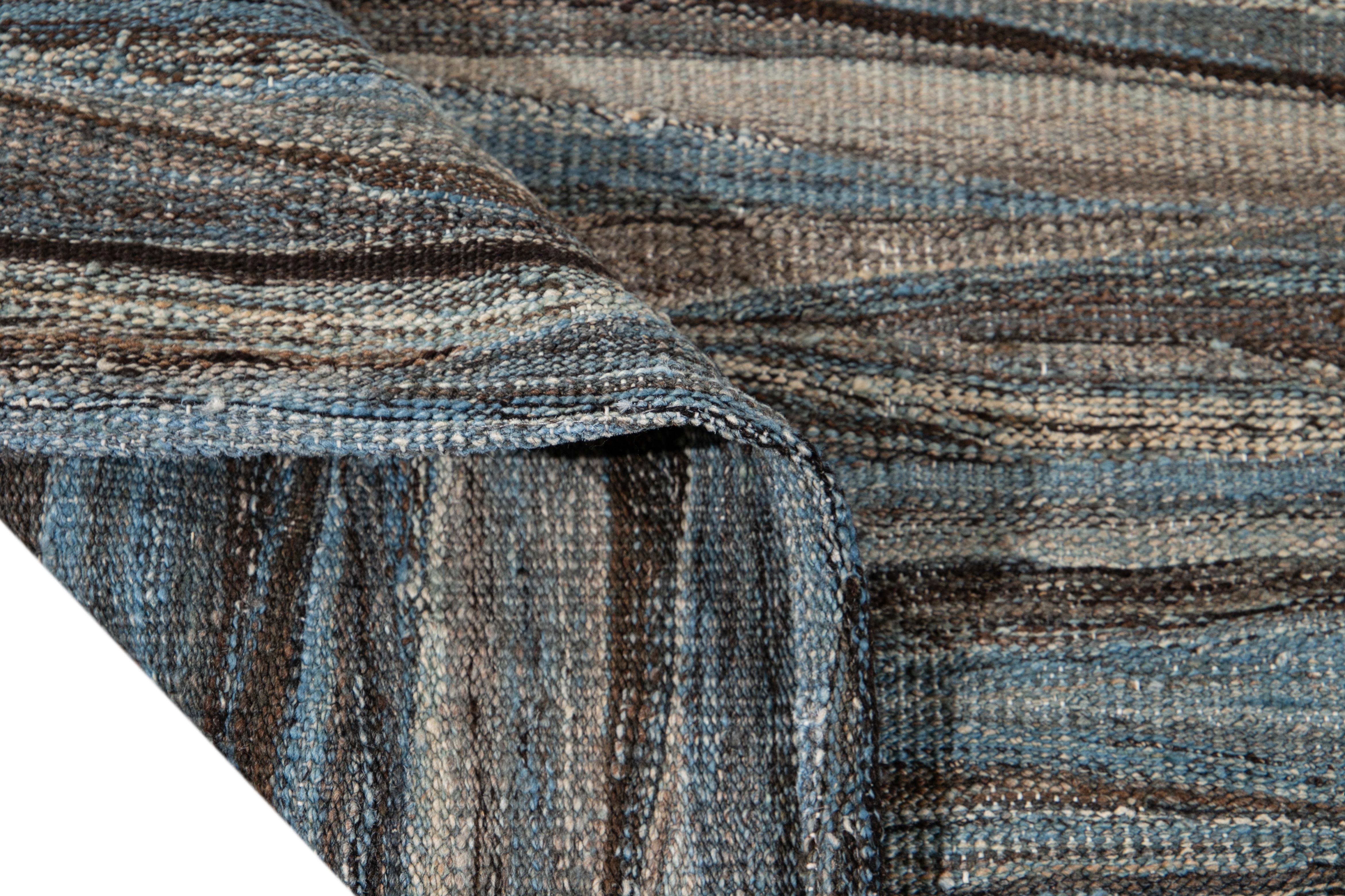 Magnifique tapis Kilim moderne en laine tissé à plat, fait à la main, avec un champ gris. Ce tapis Kilim a des accents de brun et de bleu dans un magnifique design expressionniste abstrait.

Ce tapis mesure : 9' x 11'7