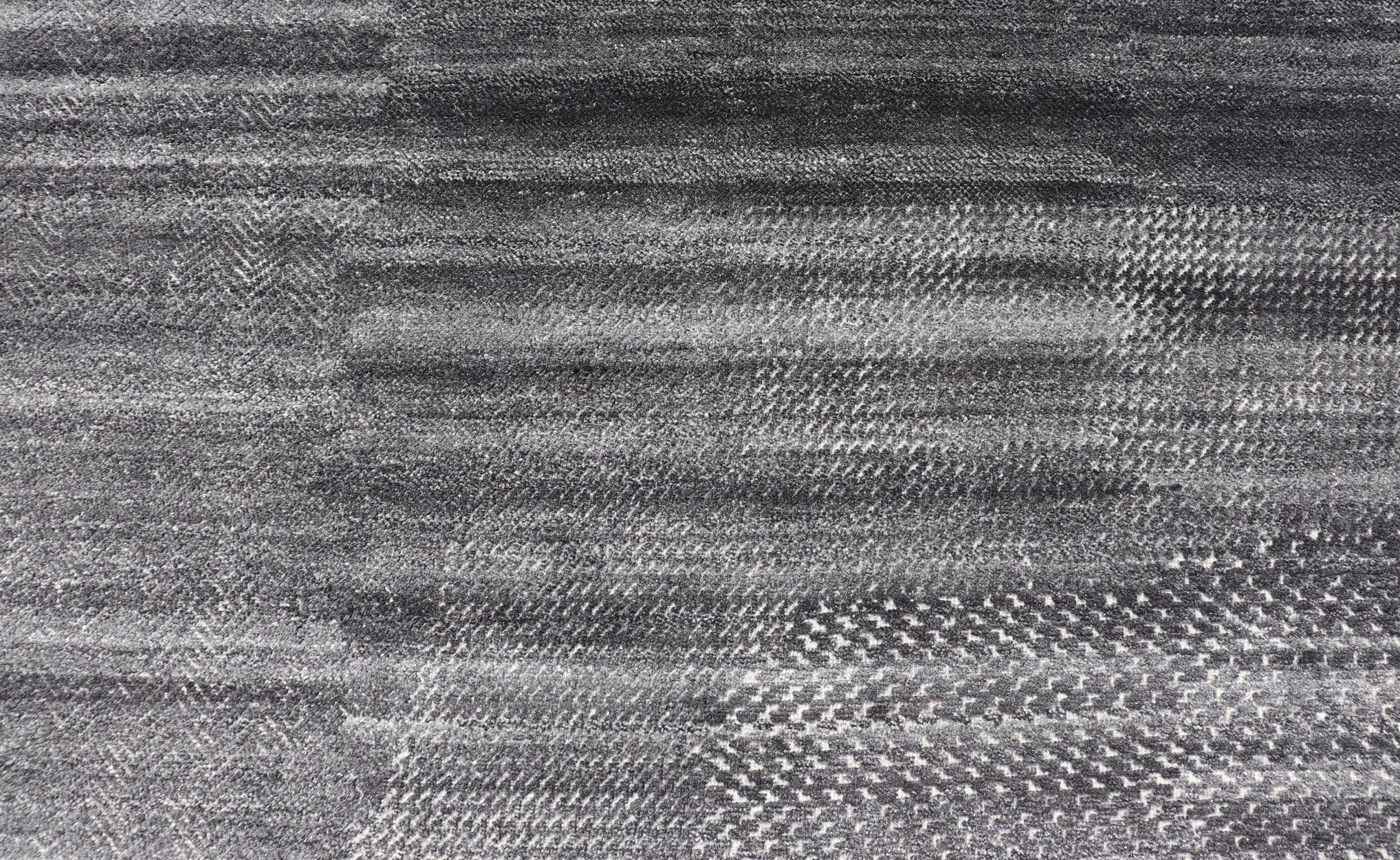 Ce tapis abstrait moderne a été noué à la main avec de la laine en Inde. Le dessin ne présente pas de motif défini, mais des 