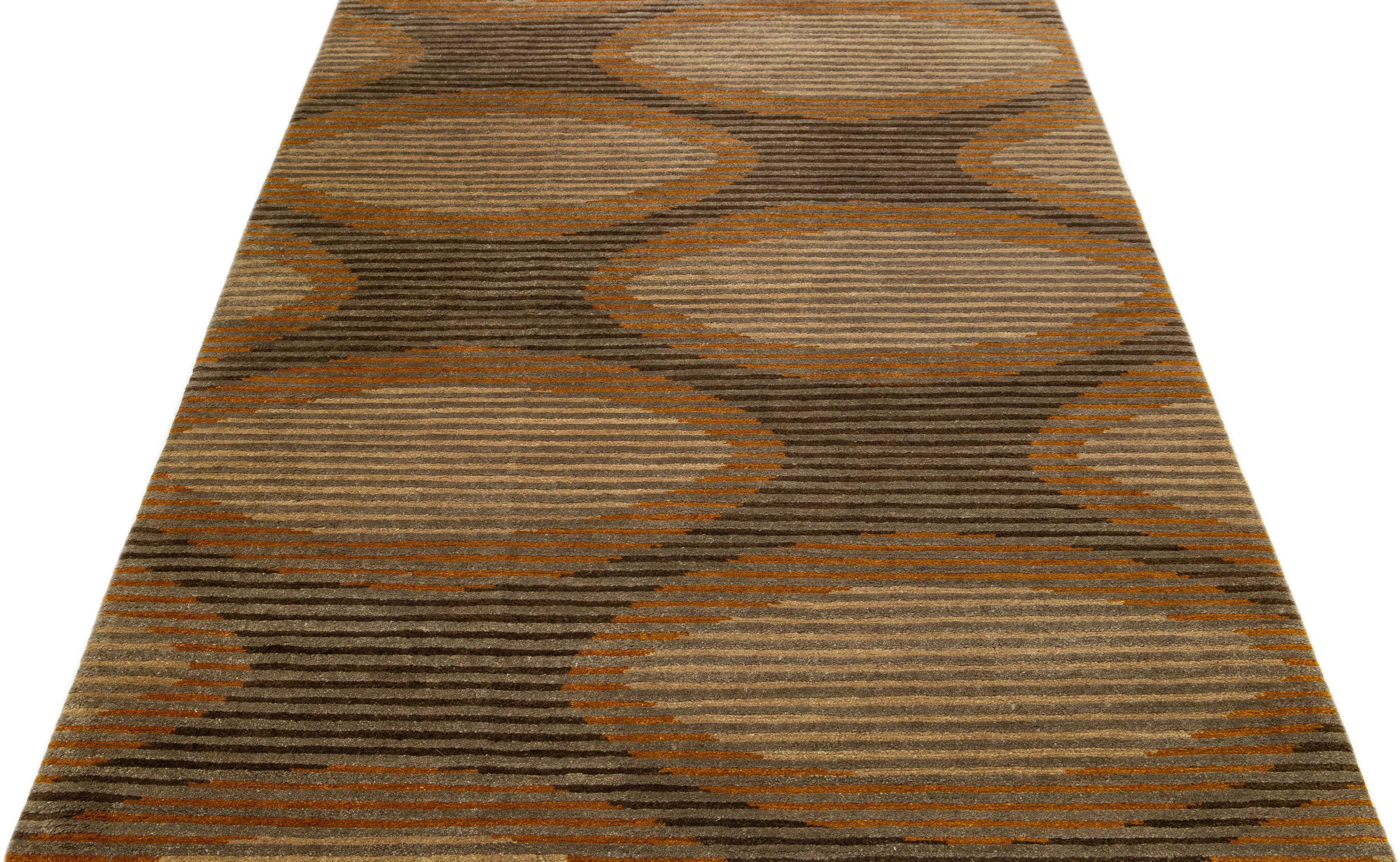 Dieser zeitgenössische Tufenkian-Teppich zeichnet sich durch ein braunes, abstraktes Feld aus. Es ist mit grauen, hellbraunen und goldroten Akzenten angereichert, die alle zu einem stilvollen Allover-Design beitragen, das die Essenz des Modernismus