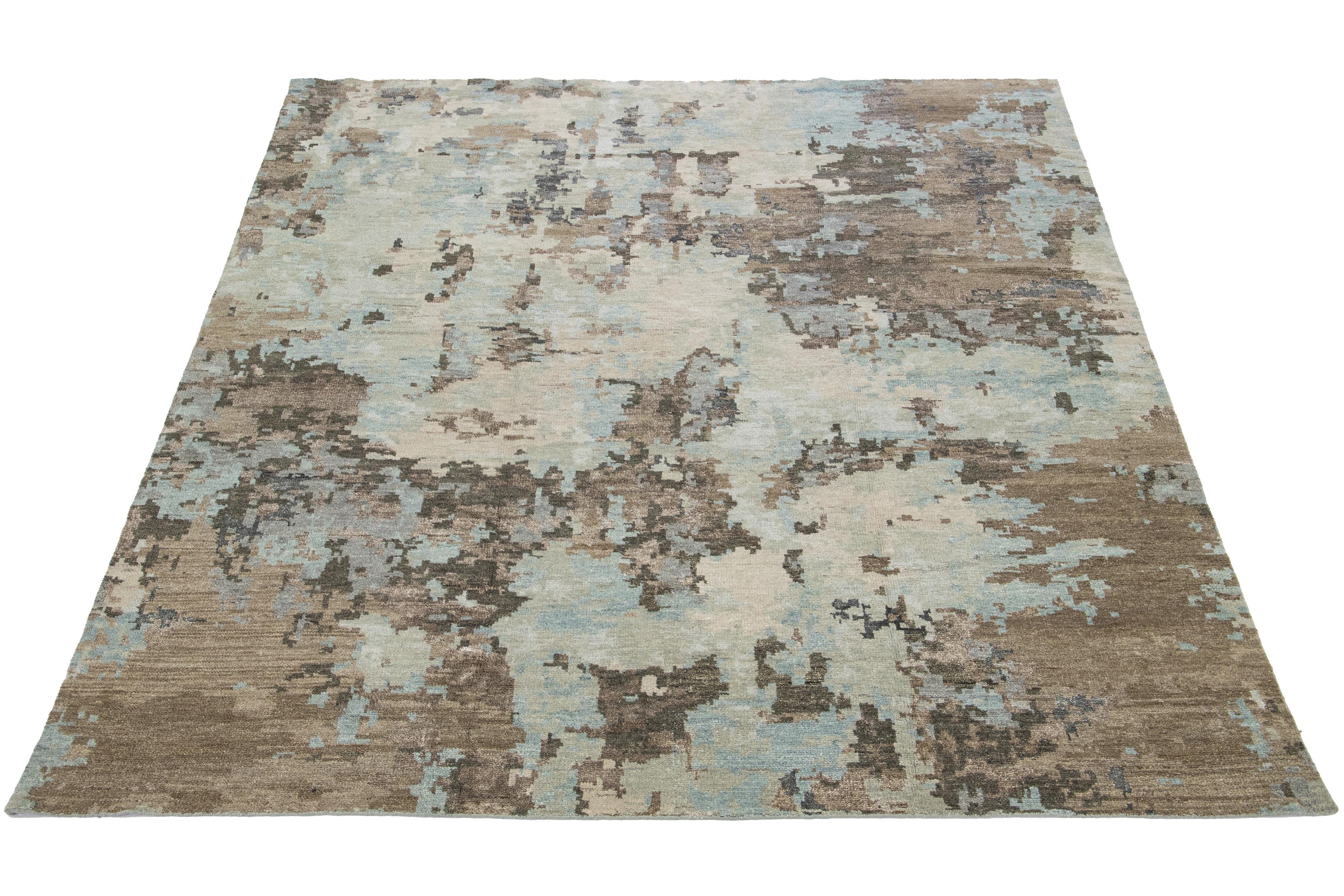 This beautiful modern hand-knotted rug is made of wool and silk and features a color field of beige, blue, gray, and brown. The rug has a stunning all-over abstract design.

This rug measures 8'3