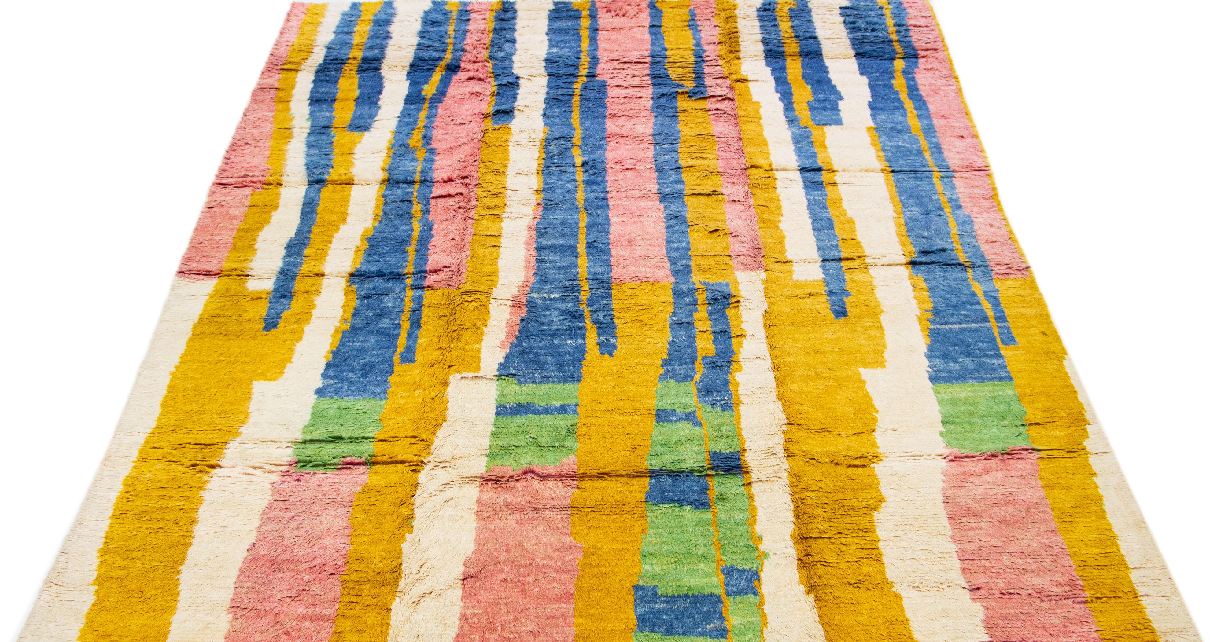 This crafted Moroccan-inspired rug features a captivating abstract striped design in a variety of stunning colors, which has been meticulously hand knotted using high-quality wool.

This rug measures 9'8