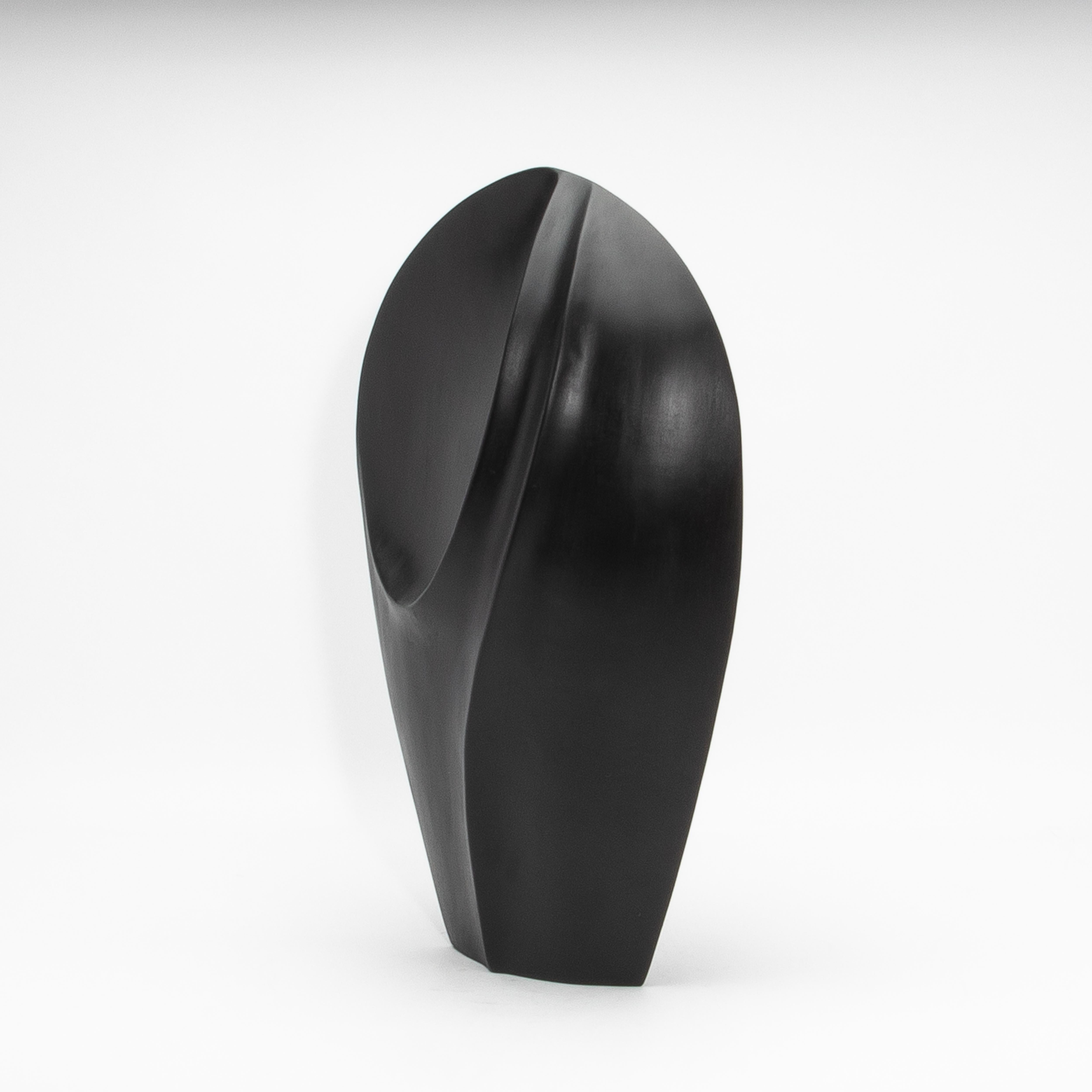 This modern abstract sculpture, titled “The Tower” by Patrick Coard Paris, epitomizes refined minimalism and artistic sophistication. Expertly hand-crafted from rich black oak, its sinuous curves and bold, architectural silhouette command attention.