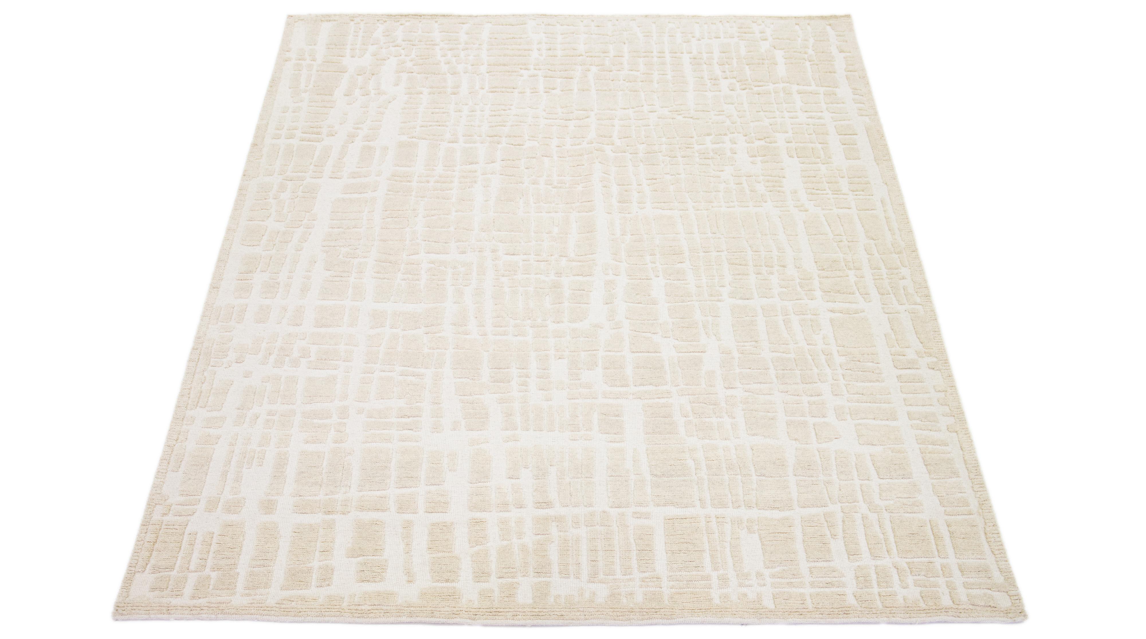 This hand-knotted wool rug showcases a modern Moroccan-inspired motif highlighting understated texture against a bold beige foundation, creating a captivating abstract Design.

This rug measures 8' x 10'1