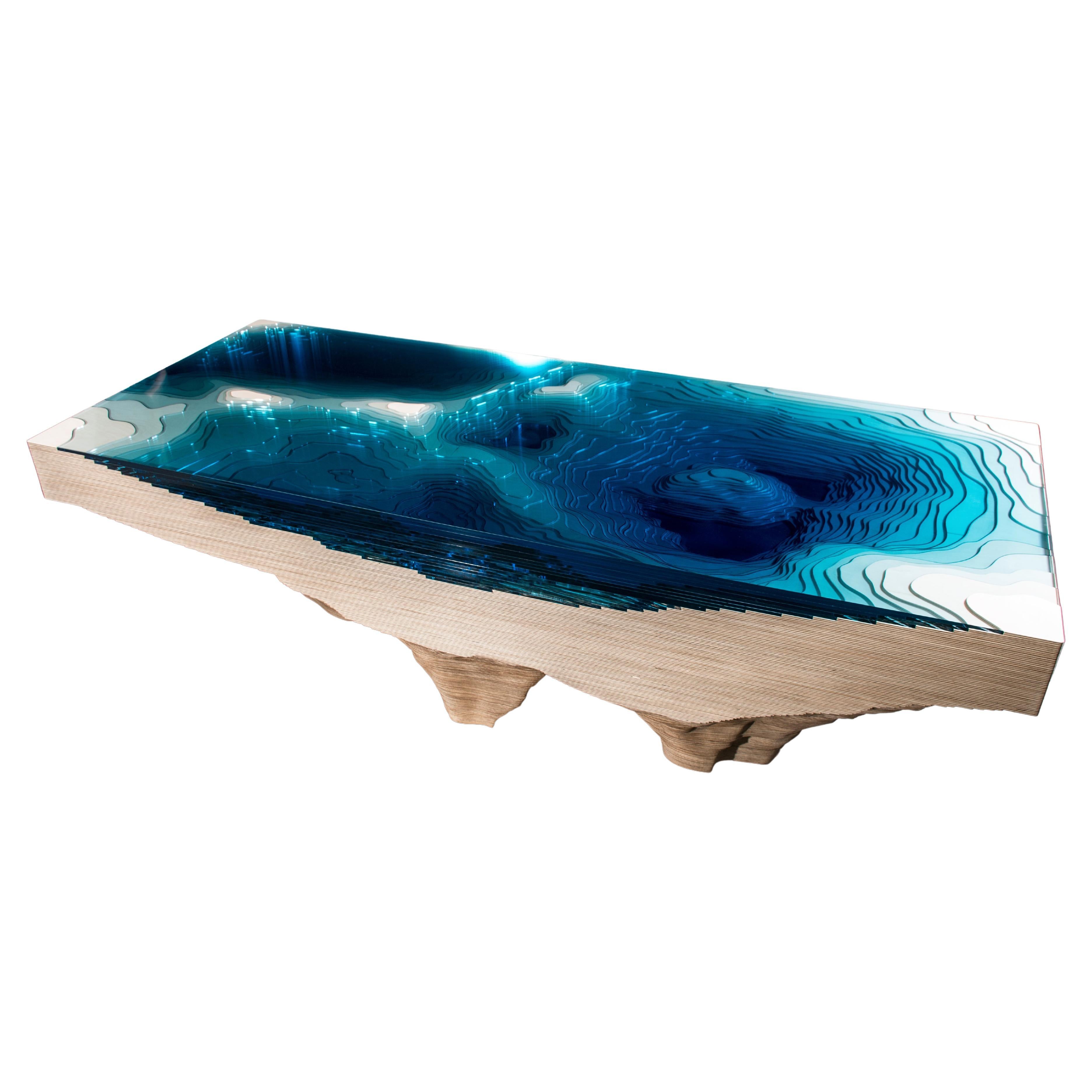 Moderner „Abyss Host“-Mitteltisch aus Holz und blau getöntem Glas
