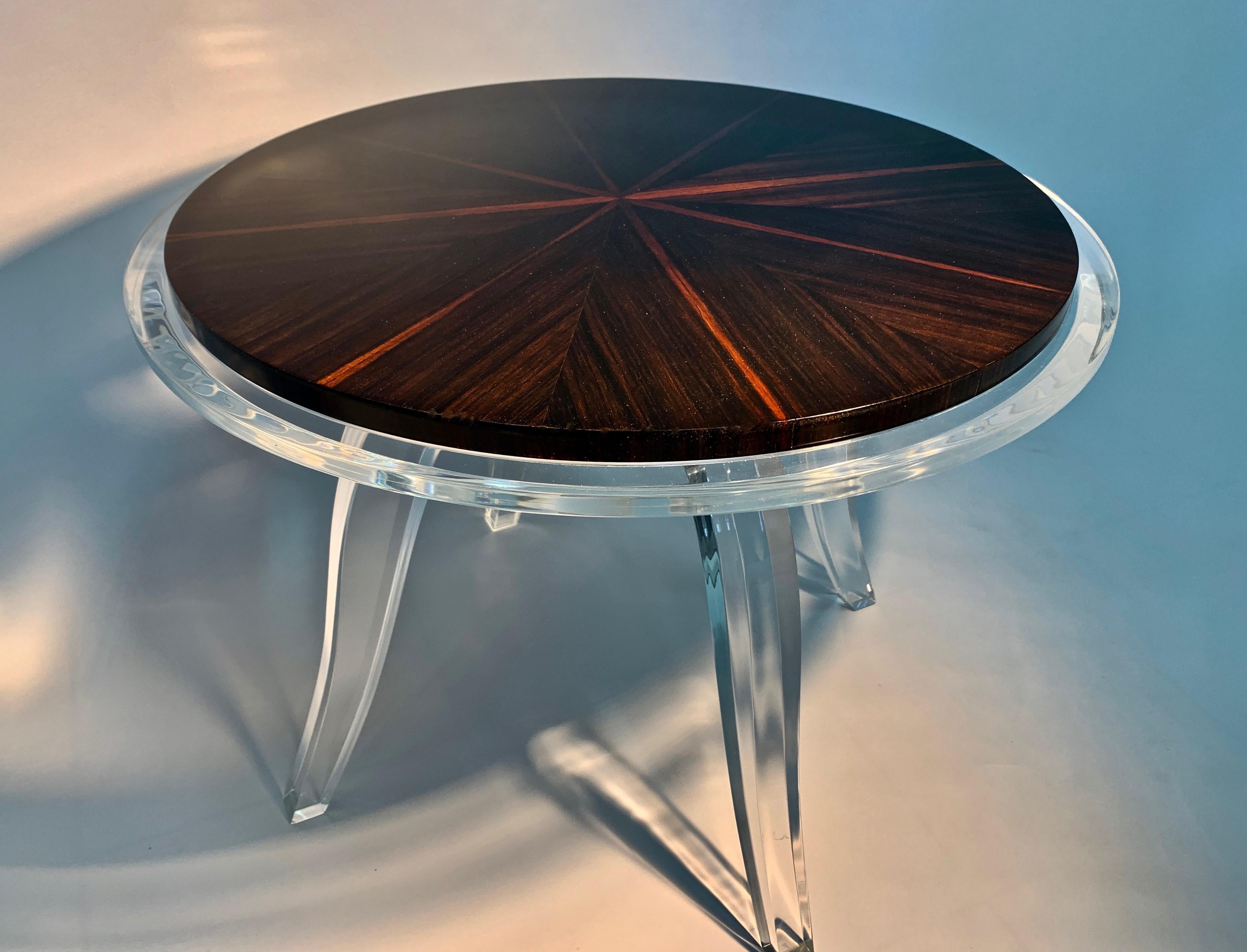The Francesca side table by Jonathan Franc - The round natural Macassar ebony top in a sunburst veneer pattern is inset into a clear acrylic top with a 1 inch edge. All raised on a center pedestal with tapering down sweeping legs. The inset top if