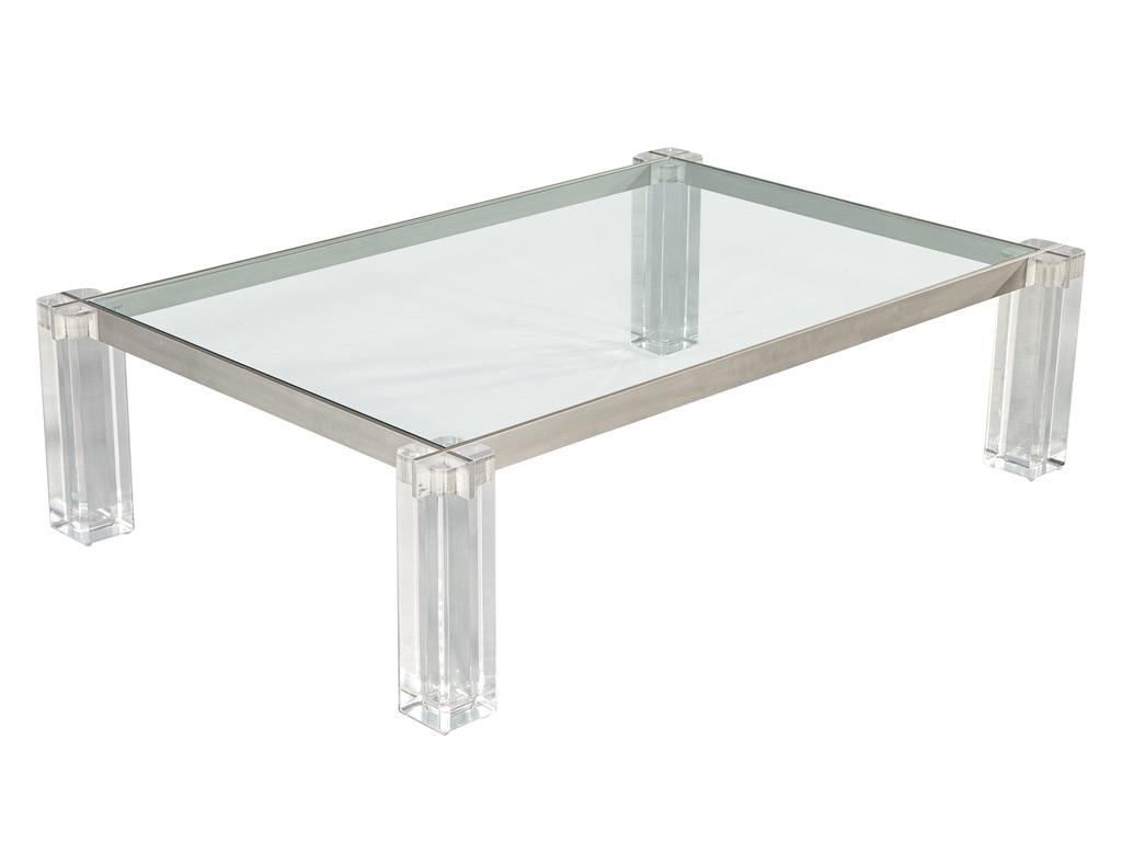 Introducing the perfect blend of modern design and functionality - the modern glass top cocktail table with a stainless steel metal frame and lucite legs. This stunning piece is proudly made in the USA, circa 1970's, and boasts a unique modern style