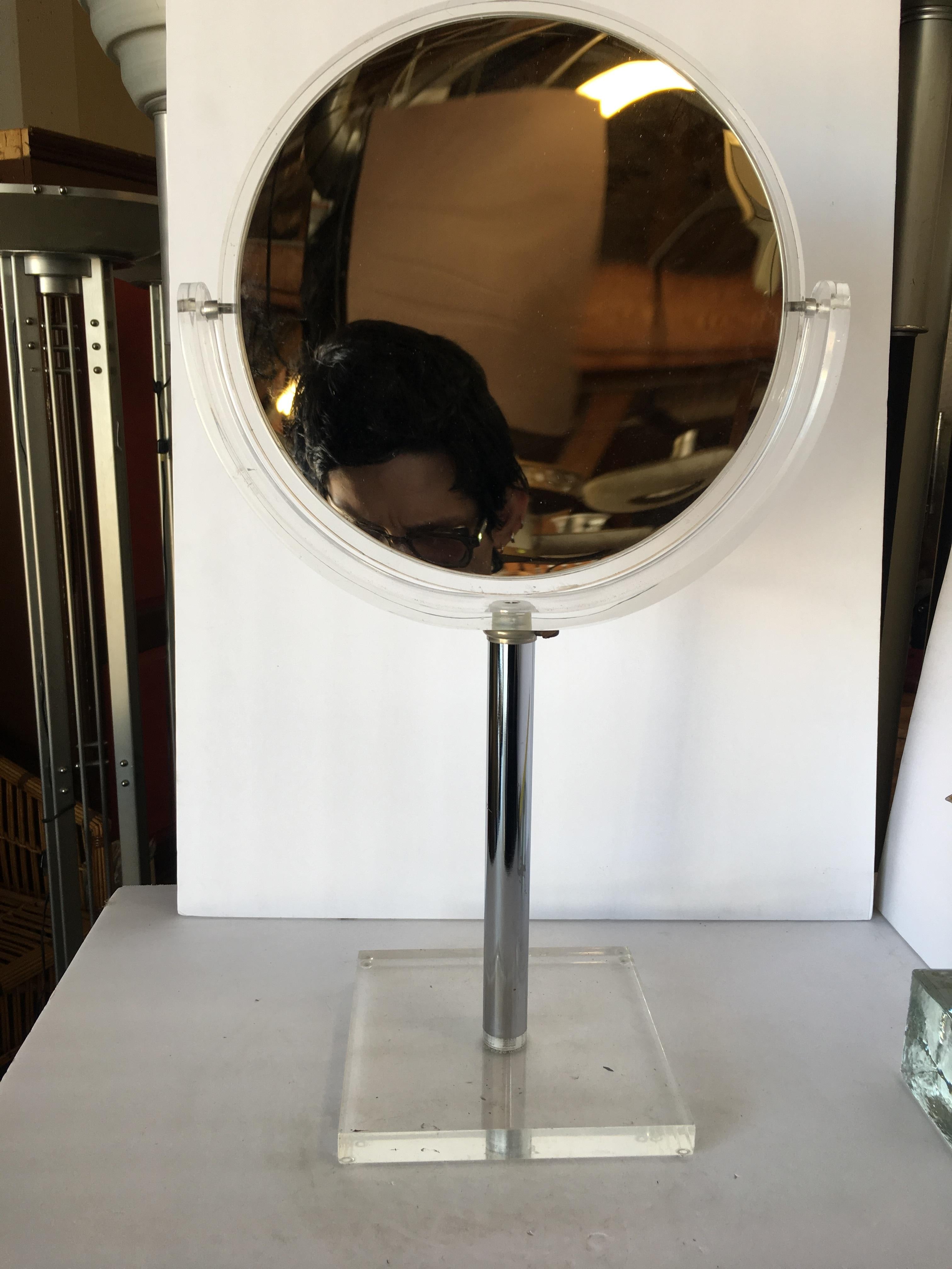 Vintage acrylic tabletop vanity mirror with double sided reversible mirror featuring a normal mirror on one side and a magnified mirror on the other. Designed by Hollis Jones.