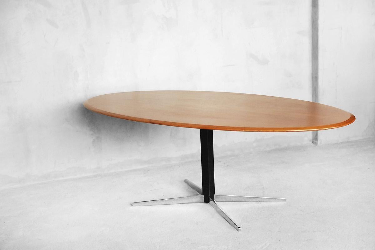 This oval-shaped modern table was designed by J.M. Thomas for Wilhelm Renz in Germany during the 1960s. Is made from teak wood and veneered. The table top can be levered up and down by way of lever as a coffee table or dining table. This hydraulic