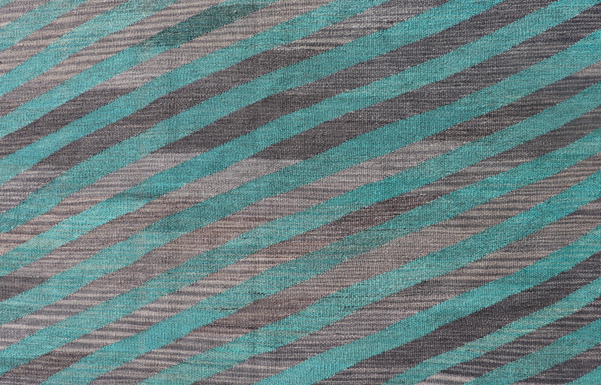 This flat-weave Kilim has been hand-woven. The rug features a modern slanted stripe design, rendered in green and shades of gray; making this rug a superb fit for a variety of Classic, modern, casual and Minimalist interiors.

Modern Kilim Rug,