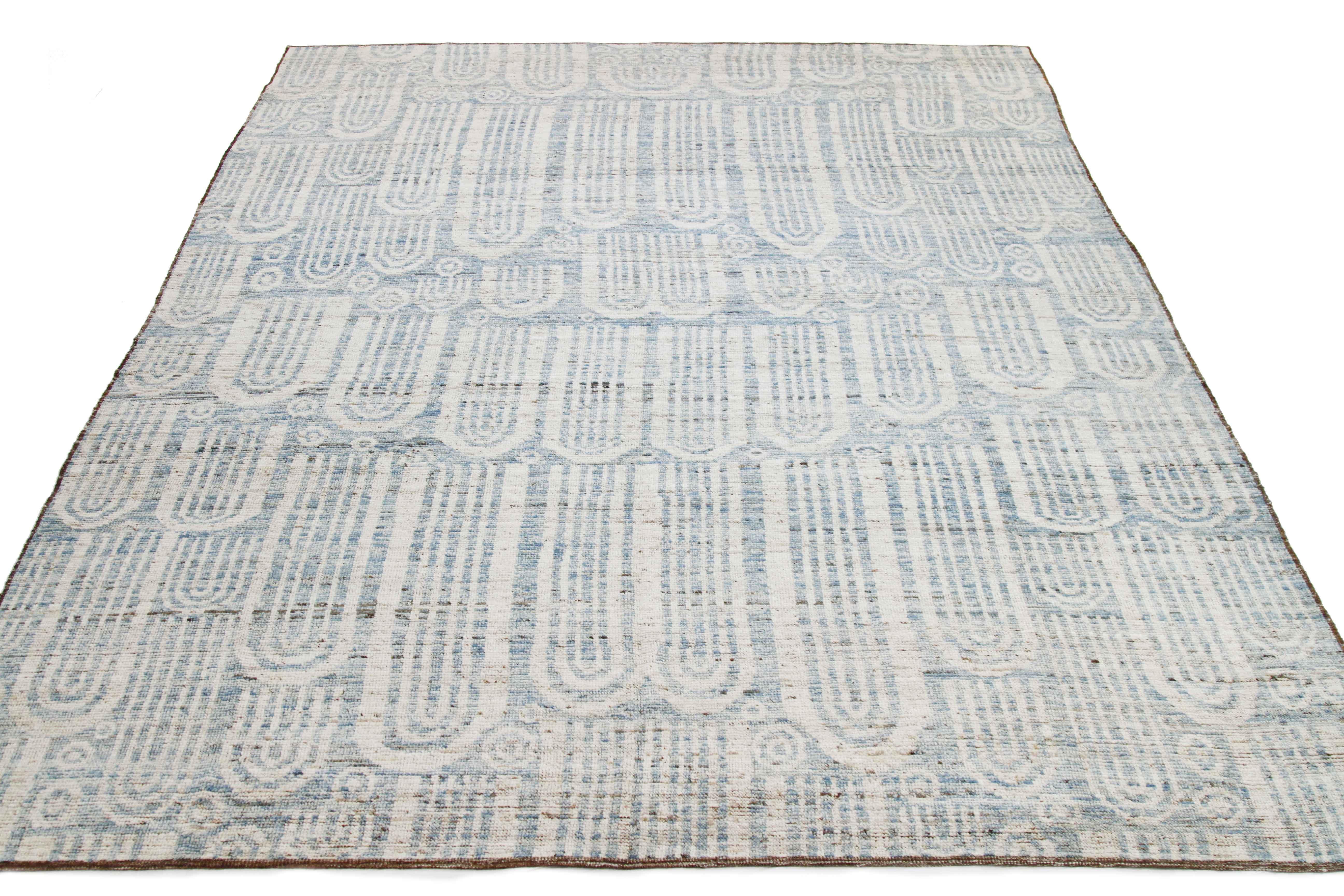 Modern Afghan rug handwoven from the finest sheep’s wool and colored with all-natural vegetable dyes that are safe for humans and pets. It’s a traditional Afghan weaving featuring a Moroccan inspired design highlighted by blue tribal patterns over