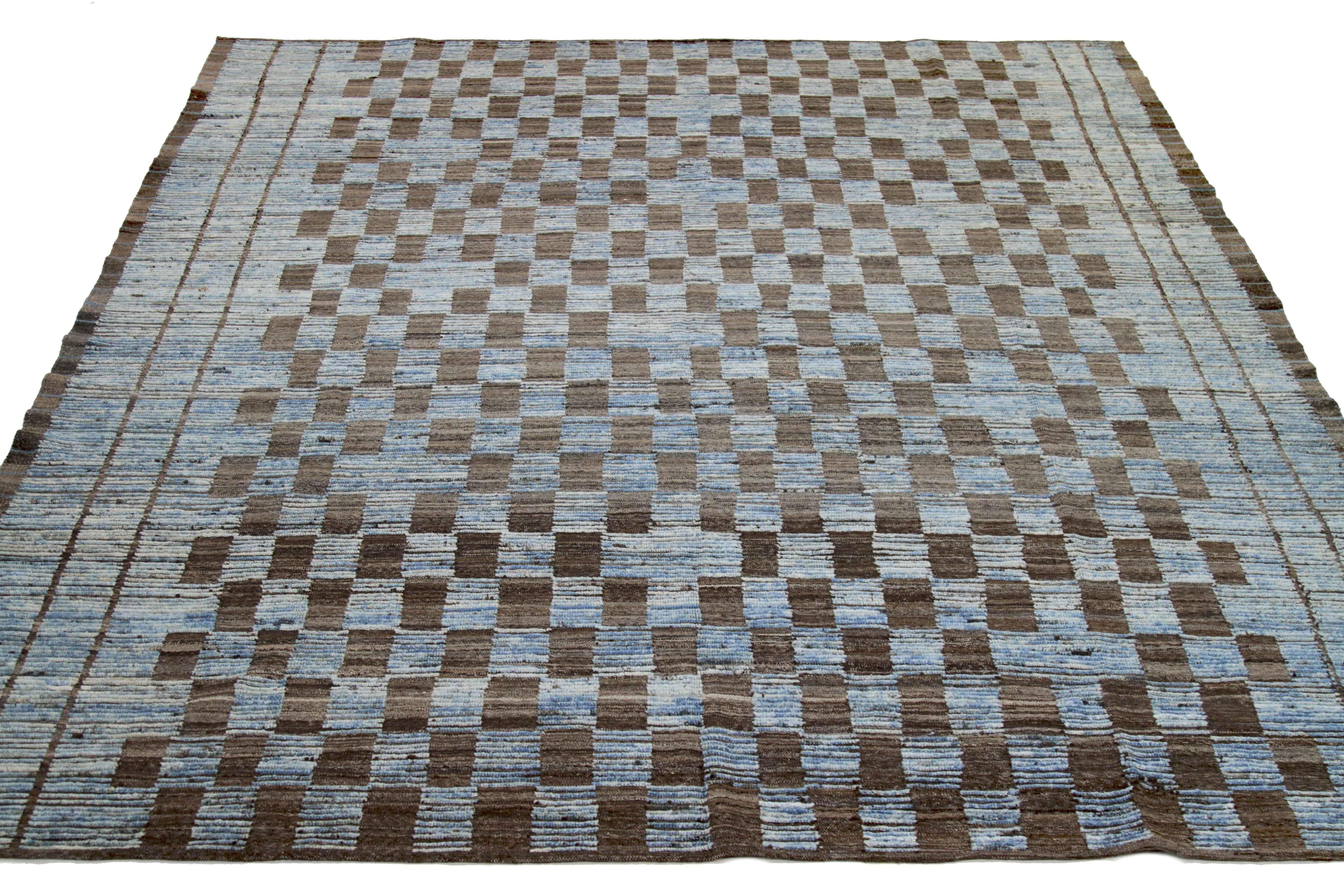 Modern Afghan rug handwoven from the finest sheep’s wool. It’s colored with all-natural vegetable dyes that are safe for humans and pets. This piece is a traditional Afghan weaving featuring a Moroccan inspired design. It’s highlighted by brown tile