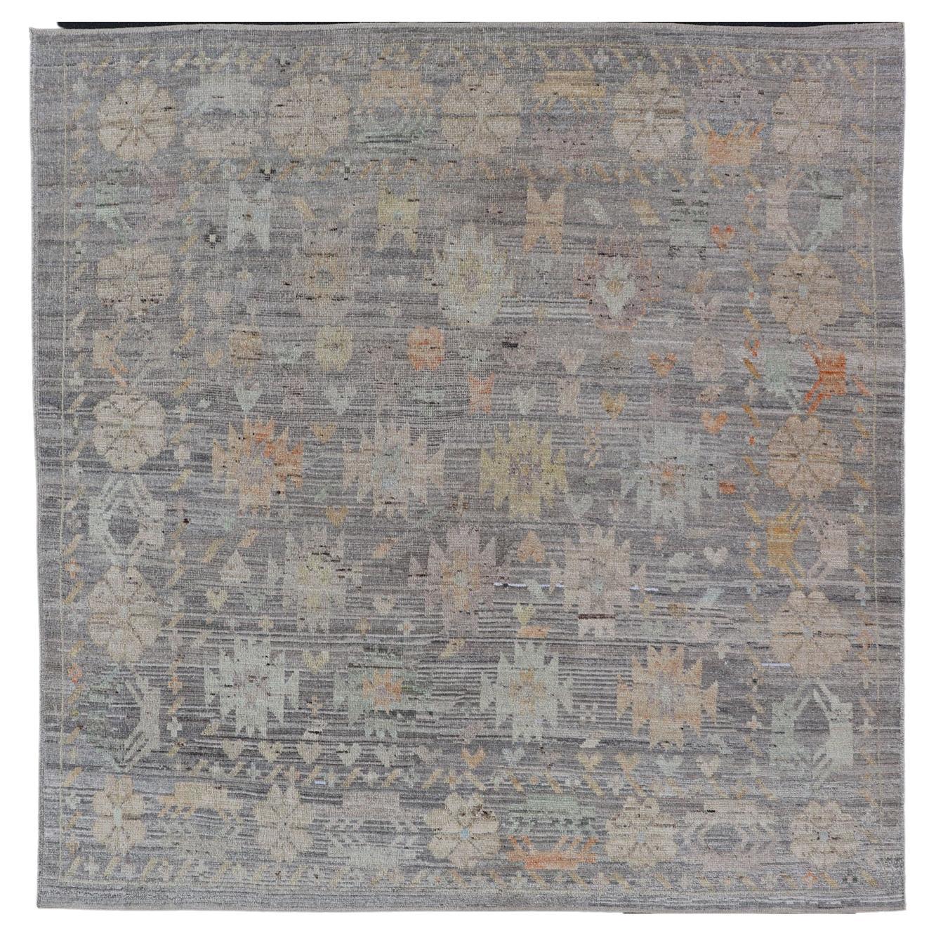 Moderner Teppich mit afghanischem Stammesmotiv in gedämpften Tönen und grauem Hintergrund