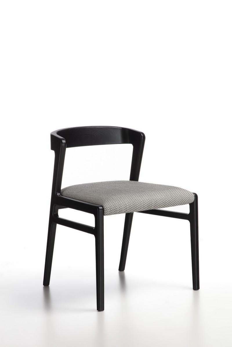 Chair from the Aida line with an essential and light design. Structure in solid wood, available in Canaletto Walnut or black finish. Seat upholstered in fabric.