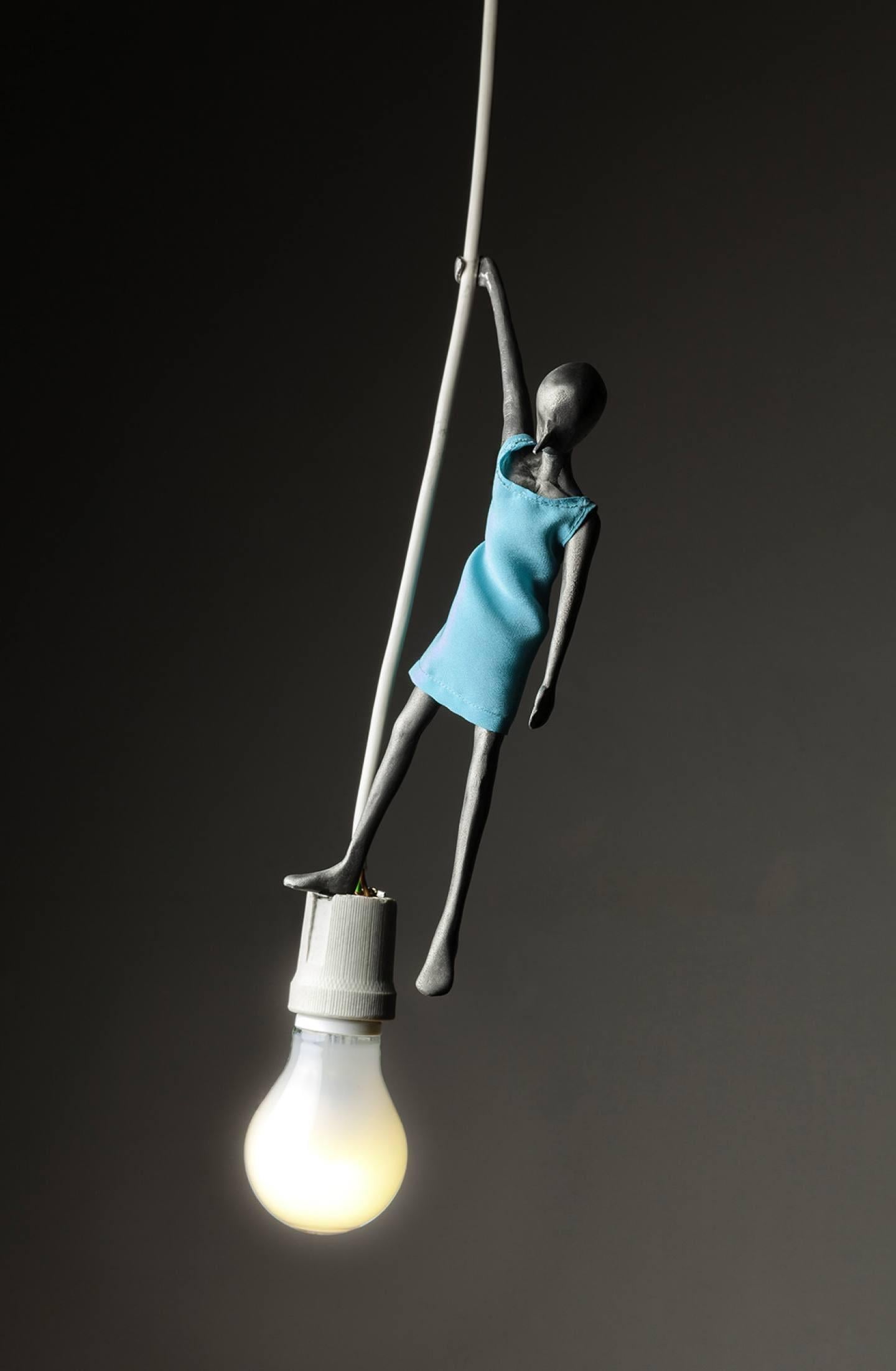 Pendent light made in lost-wax casting aluminium for Dilmos Milano. Alex Pinna created a collection of three pendent lights called Lampwick, Blue Fairy and Duo. This piece, Blue Fairy, is a small sculpture standing on a LED bulb. In all works of