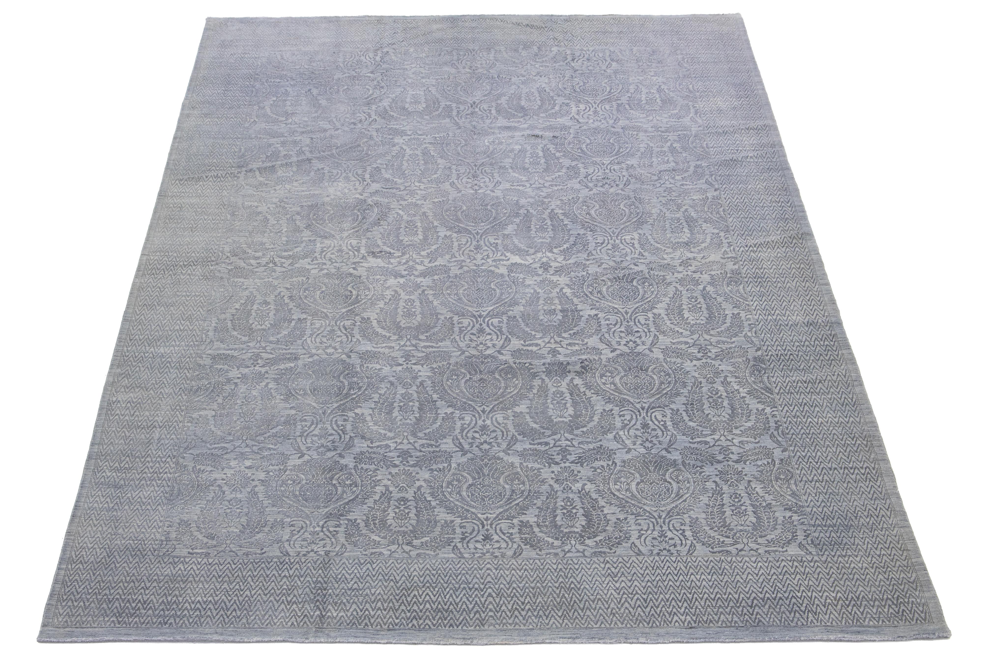 This hand-knotted wool rug showcases a light gray field. It's designed with a stunning allover floral pattern and accented with dark gray hues in a Transitional allure.

This rug measures 9'11