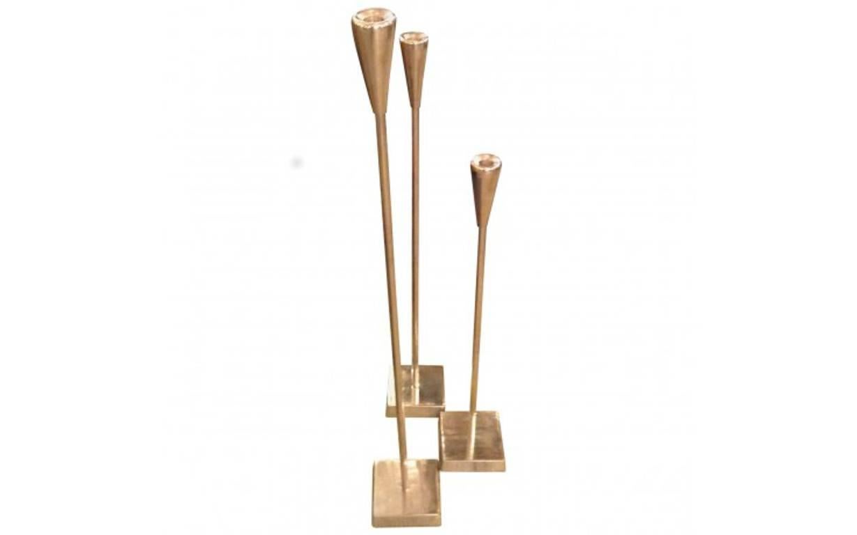 Modern and elegant, this trio of tall, slender candle sticks will be the perfect touch beside a master bathtub or gathered on a fireplace hearth. Fashioned from aluminum, of varying heights, the polished silver finish gives them an extra dose of