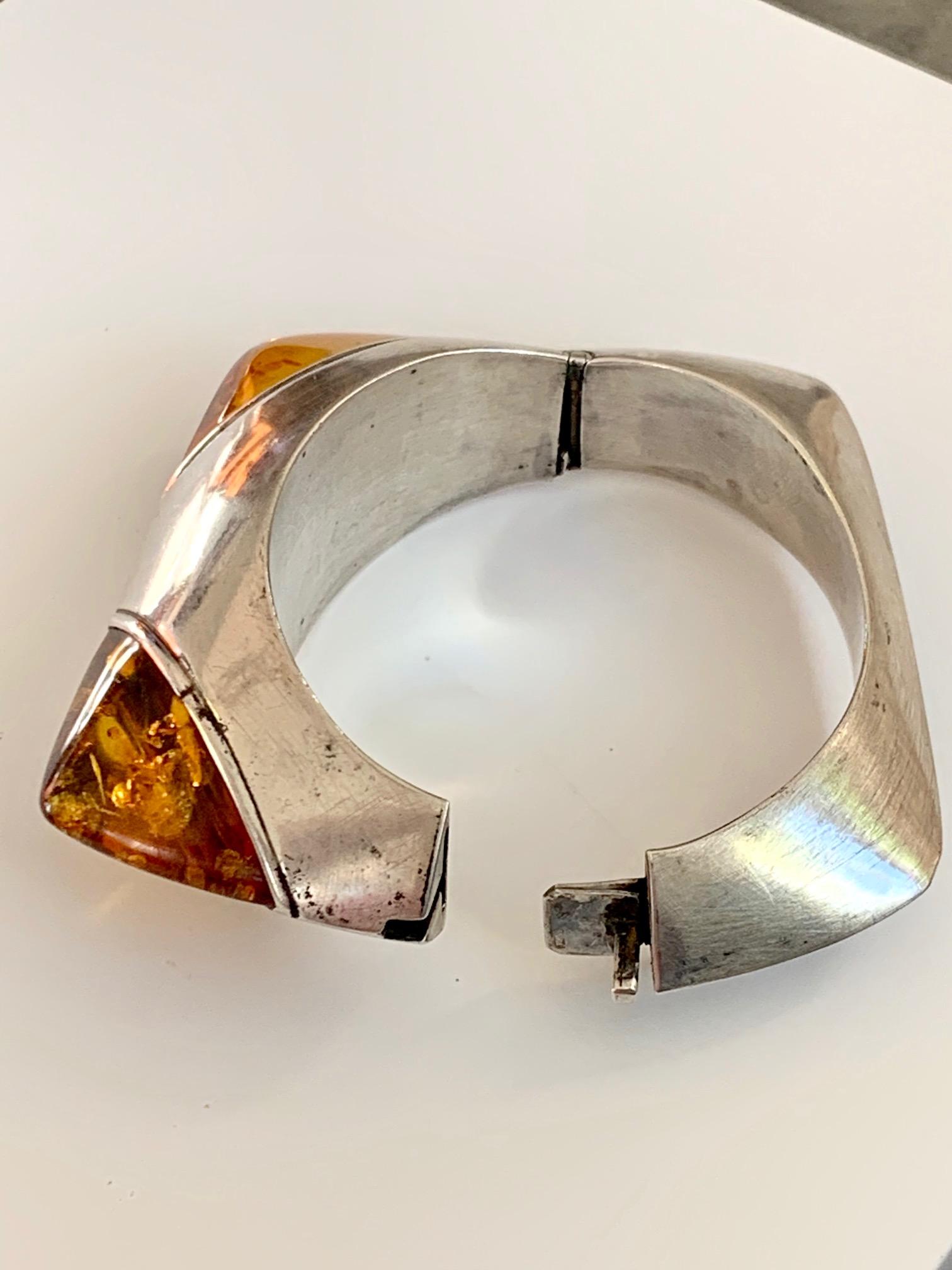 This signed Gloria bangle bracelet features two large triangle shaped Amber stones  in the corners of the top of this bangle.  

The bangle is stamped .925 Sterling. 

Measurements:  Outside circumference measures 9