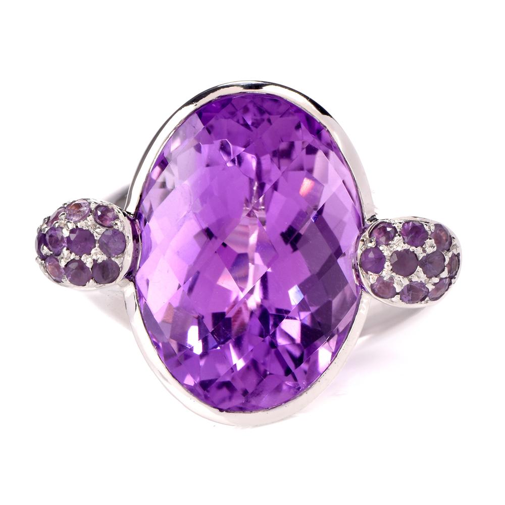 This stylish modern amethyst cocktail ring is crafted in 18-karat white gold. Displaying a swirl design with a elevated bezel-set centered amethyst weighing approximately, 13.91 carats. Further embellished by 20 small round-cut pave-set ametheyst