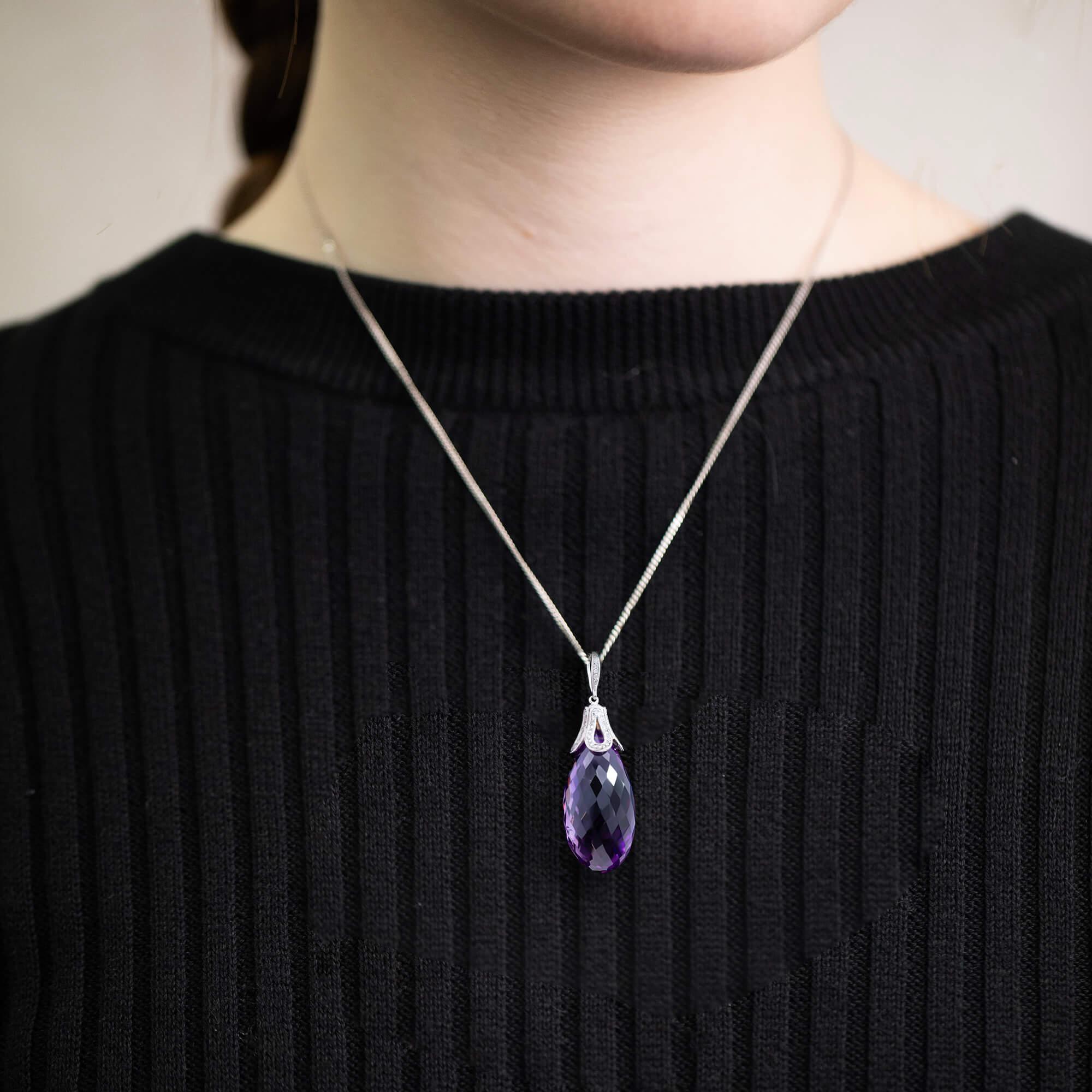 Modern pendant featuring a briolette cut amethyst with a diamond pave set cap and bale.

Gemstone: One Amethyst, briolette cut, good purple material, pique clarity, estimated weight 85.0ct
Diamonds: Eighty six round brilliant diamonds total