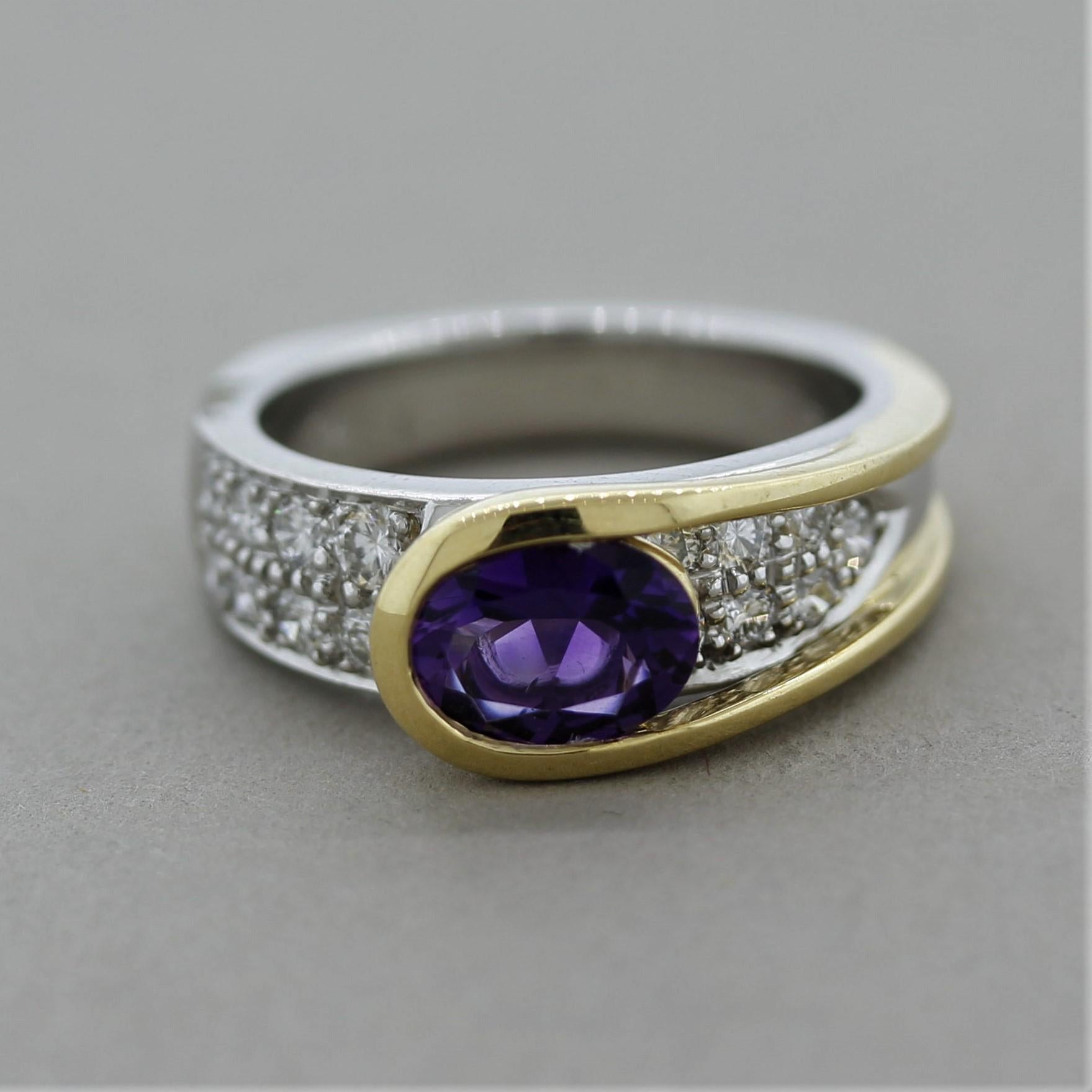 A stylish modern designed ring featuring an oval shaped amethyst weighing 1.02 carats and set in 18k yellow gold. It is accented by 0.61 carats of round brilliant-cut diamonds set below the amethyst in platinum. The two-toned design, combining