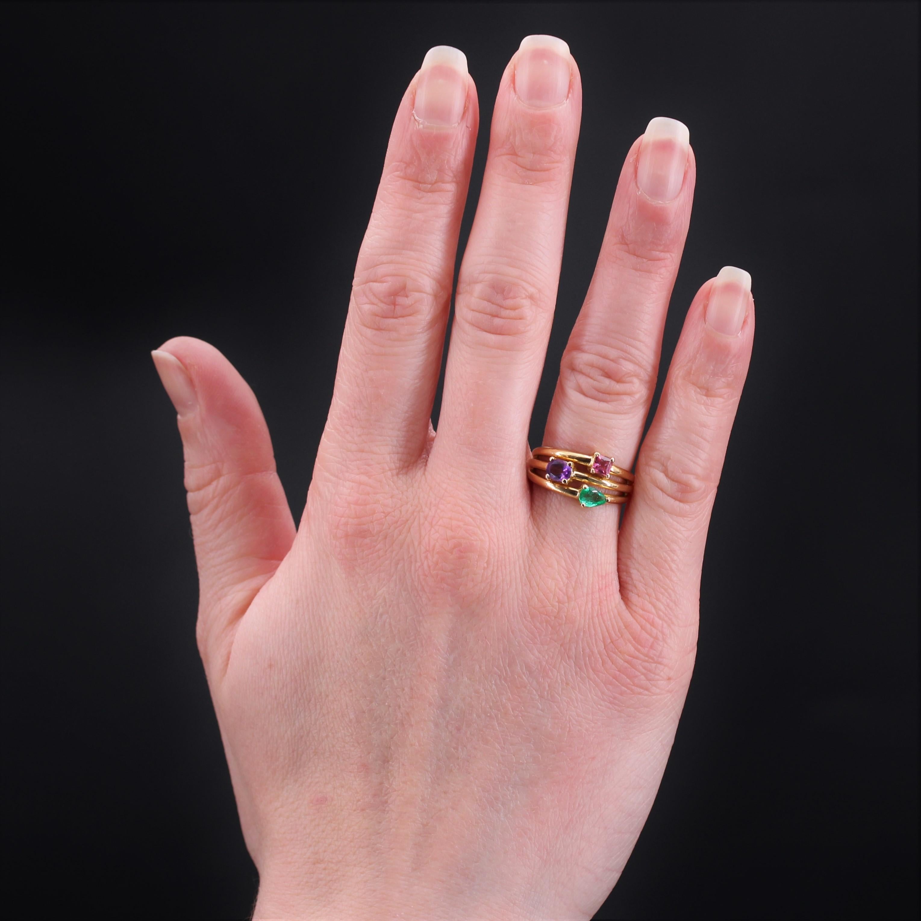Ring in 18 karat yellow gold, eagle head hallmark.
Second- hand gold ring, it is formed of 3 rings openworked between them which join to form only one at the base. Each ring is decorated with a gemstone or fine stone held in claws : a pear emerald,