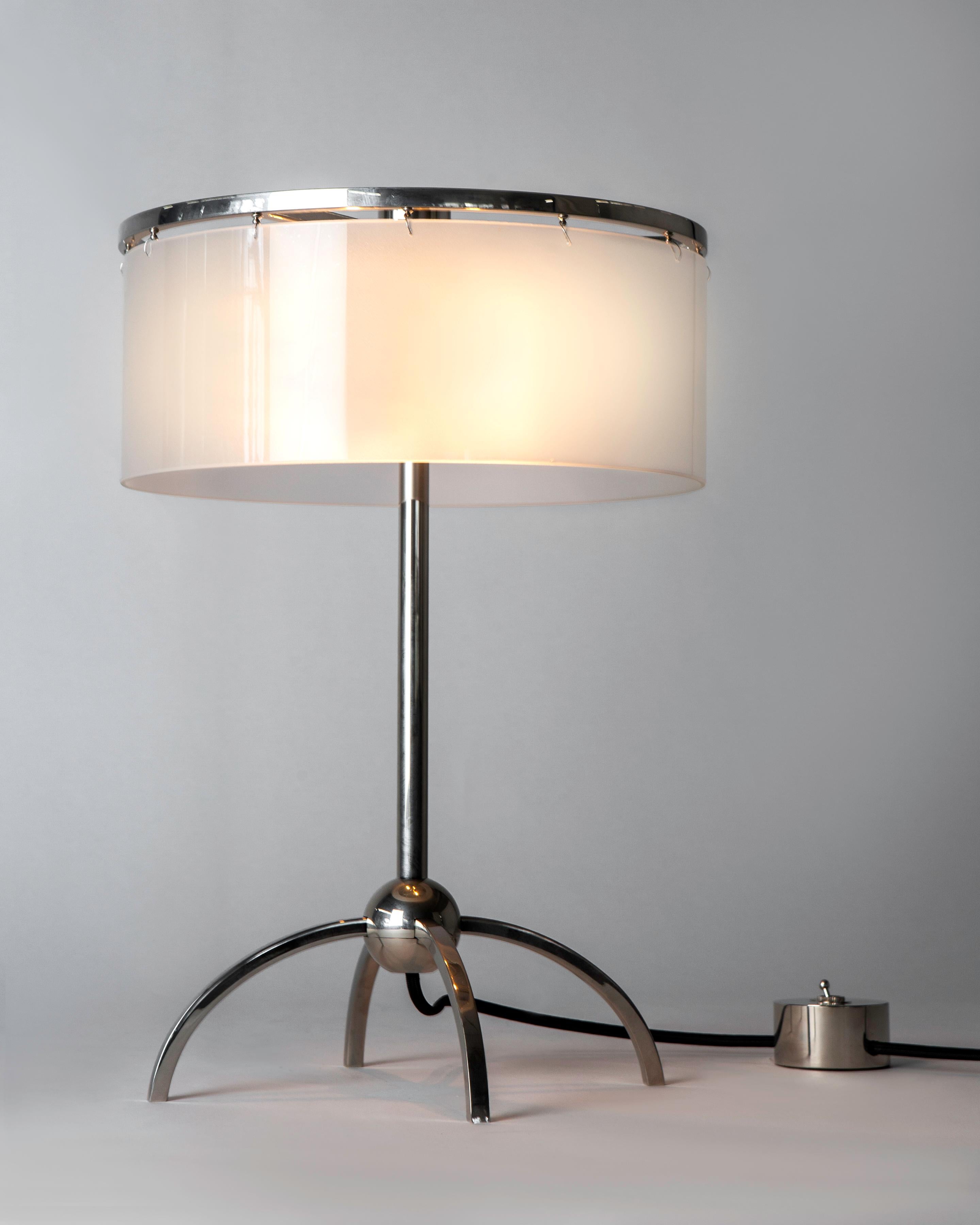 RTL5010
A modern table lamp having a slender round stem connecting to a round ball base with four curved square-sectioned legs. The frosted glass drum shade floats below a minimal circular top frame, obscuring a two light cluster. A decorative