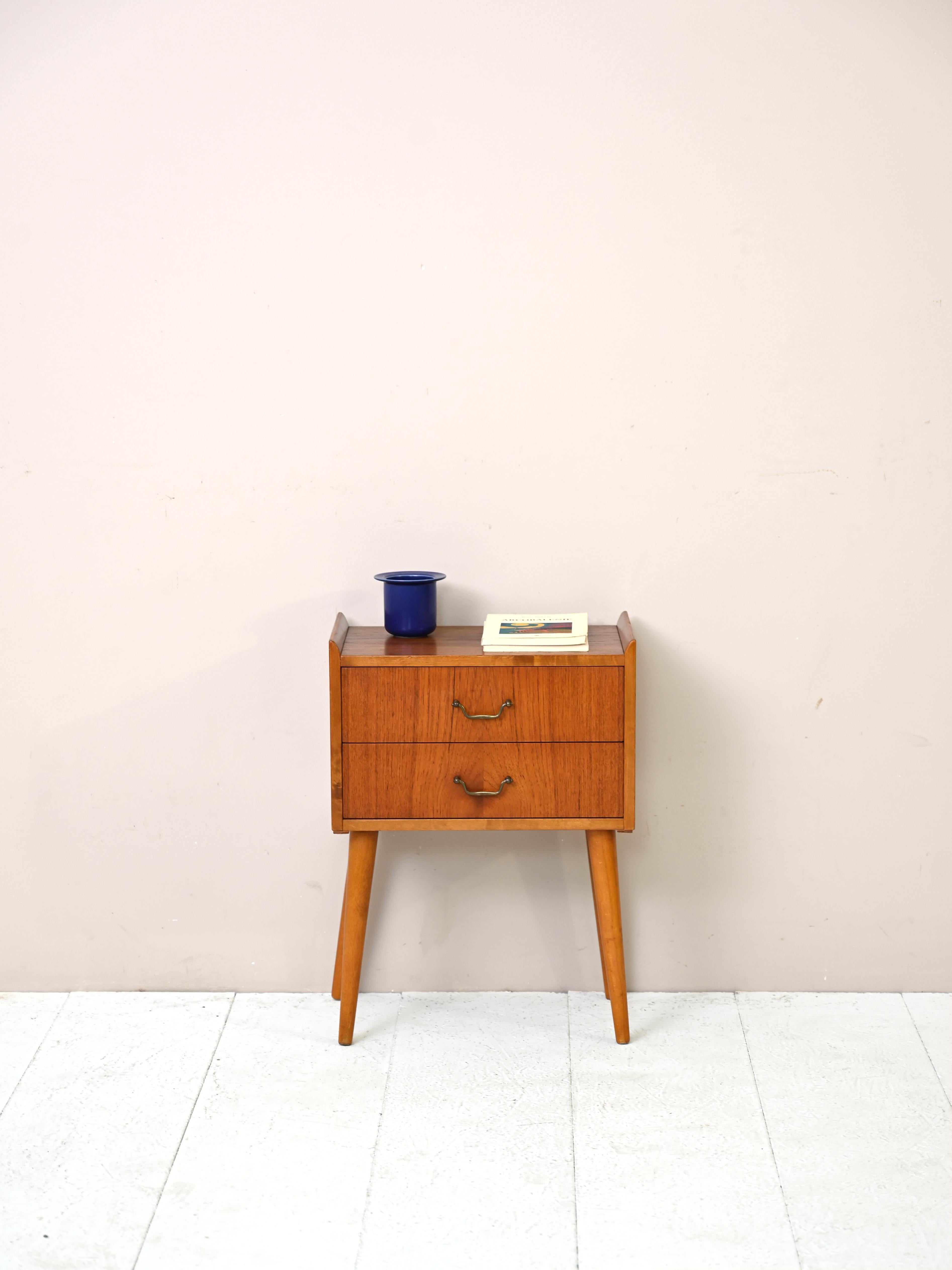 Original nightstand from the 1960s of Scandinavian manufacture.
This cabinet, ideal for the bedroom but also for the entryway or hall, features a
drawer with a metal handle and a magazine rack top.
Its peculiarity lies in the unusual shape of the