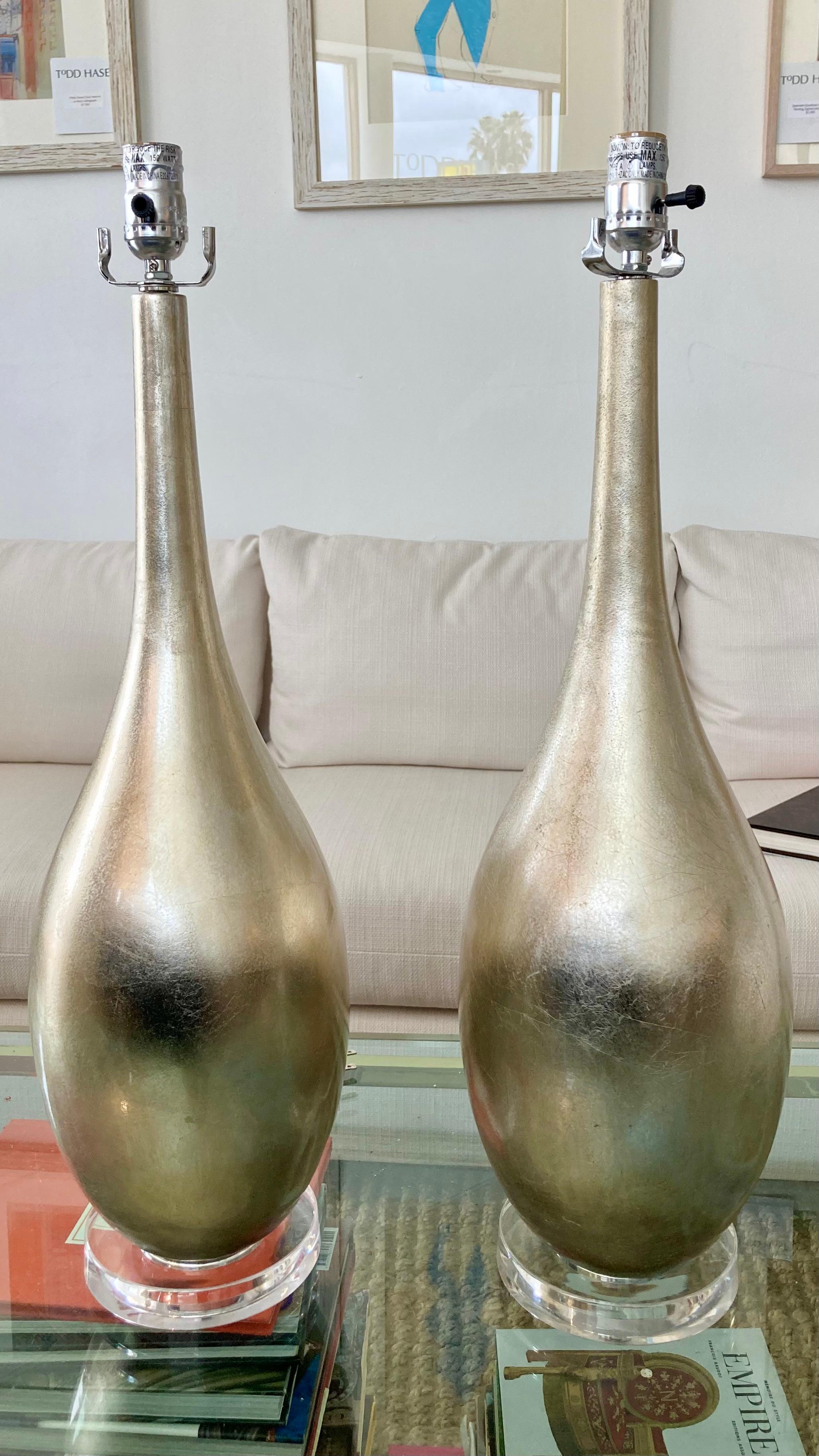 Beautiful pair of modern antique silver leaf table lamps with lucite bases. Very nice leaf finsi in a warm silver tone. Add a classic modern touch to your home.