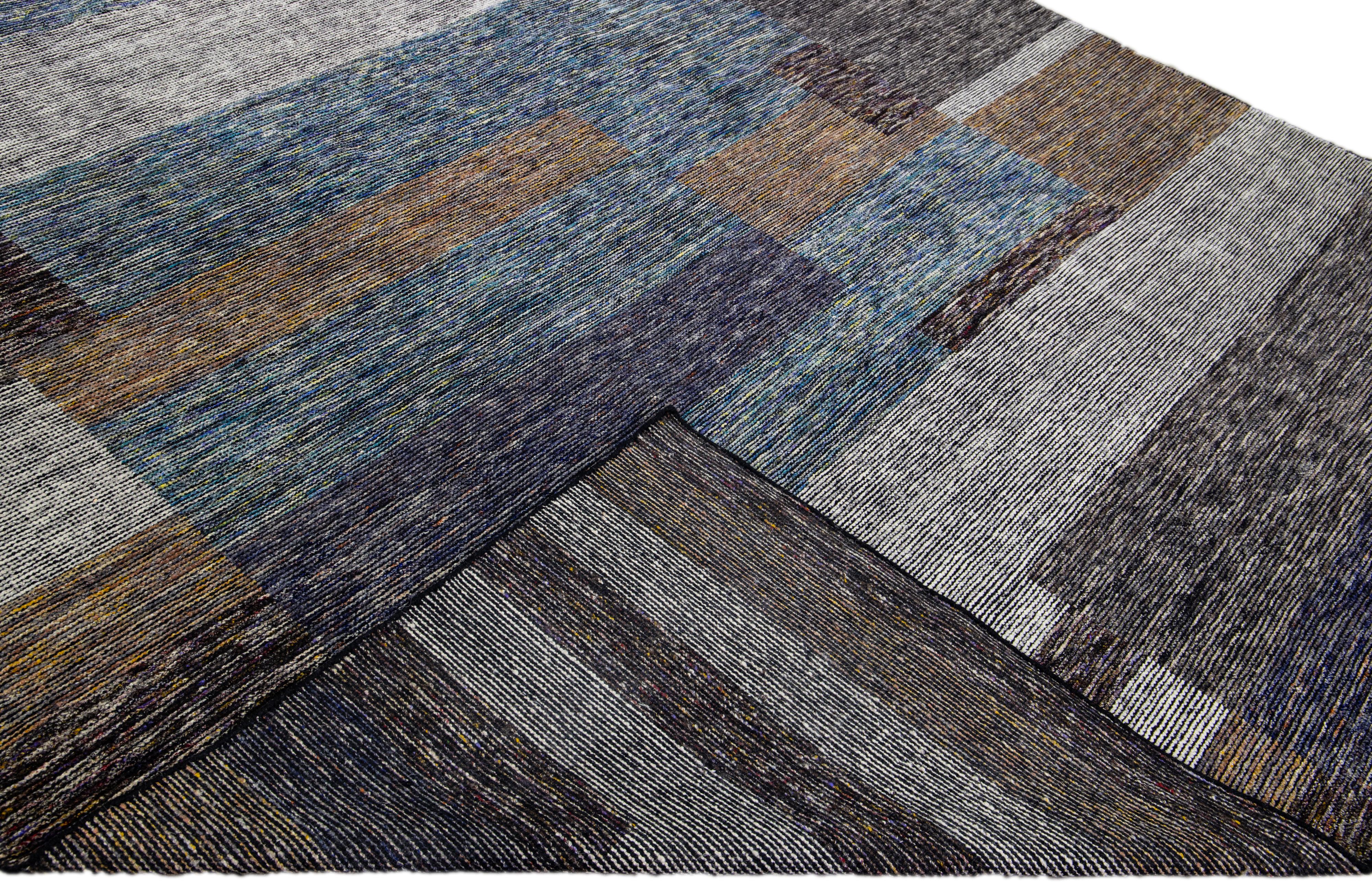 Wunderschöner, moderner, handgeknüpfter Wollteppich der Collection'S Safi von Apadana mit erdigem Farbfeld. Dieser moderne Teppich mit blauen, grauen und braunen Akzenten hat ein wunderschönes abstraktes Design.

Dieser Teppich misst: 9'4