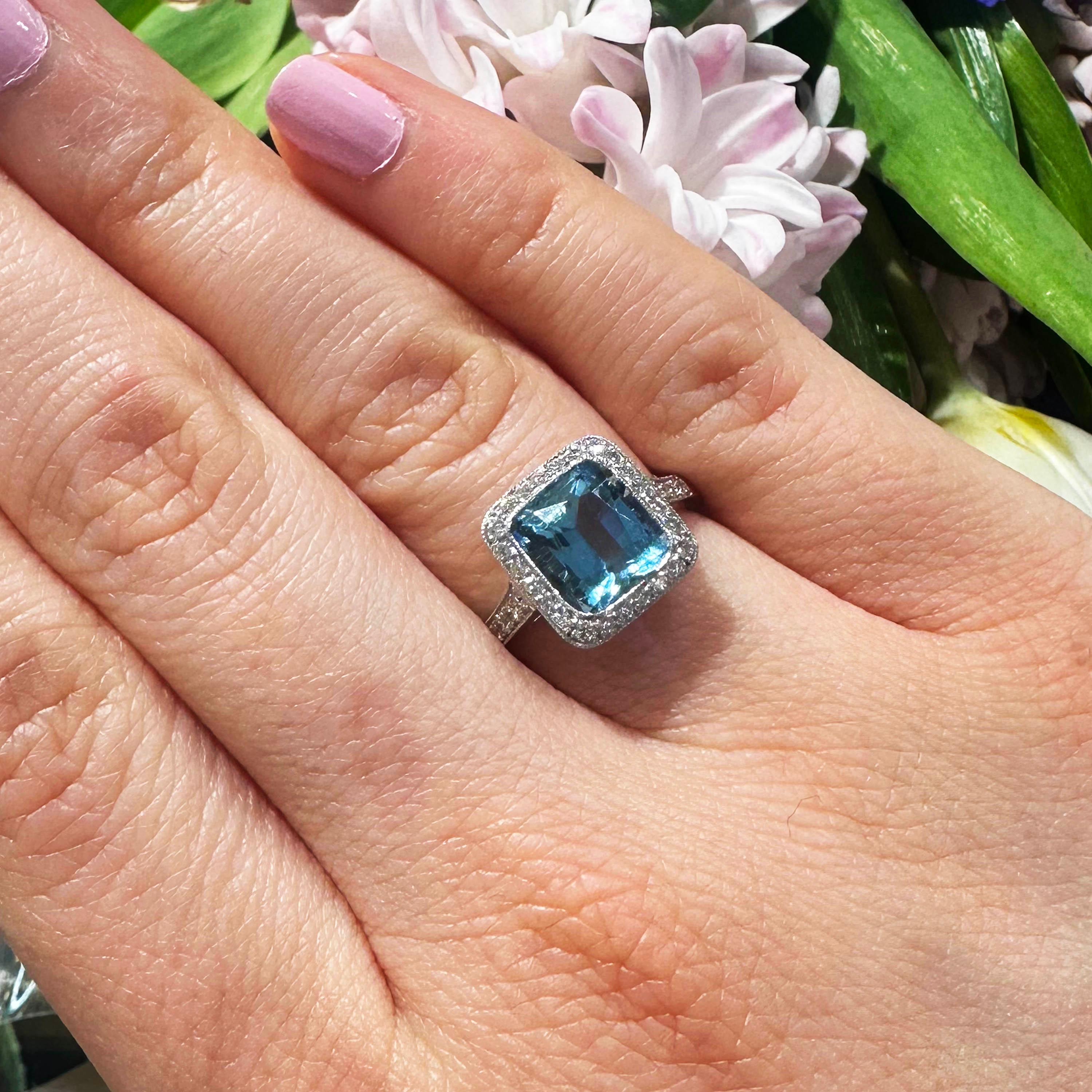An aquamarine and diamond ring, set with a 2.59ct cushion shaped aquamarine, surrounded by grain set, round brilliant-cut diamonds, with four, round brilliant-cut diamonds set in each shoulder, with a total diamond weight of approximately 0.25ct,