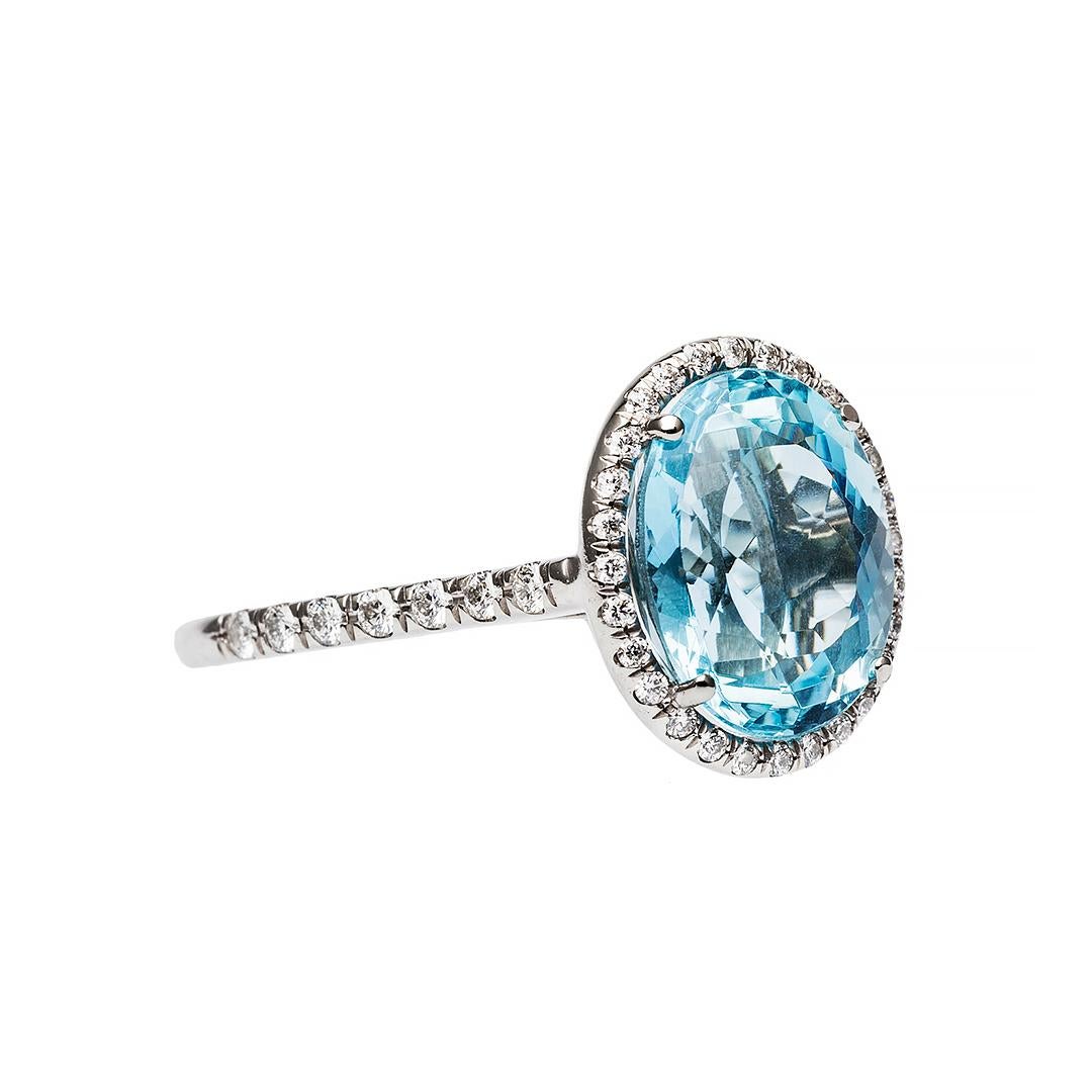This is a majestic 18k white gold, aquamarine and diamond engagement ring that was made in the past 20 years. The ring centers a four-prong set Oval Mixed Cut natural aquamarine gauged at approximately 11mm x 9mm weighing an estimated 3.30cts. The