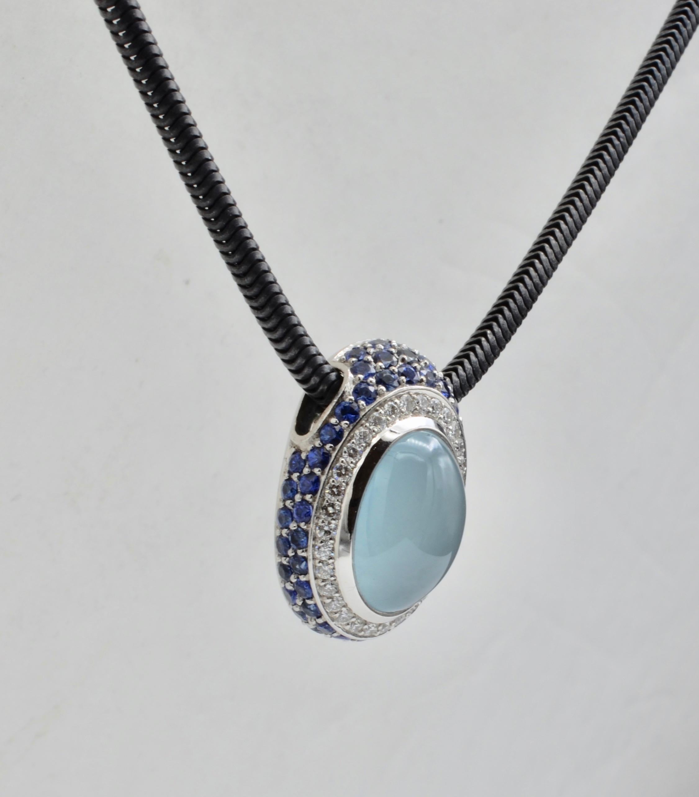 This yummy milky aquamarine is beautifully framed in a blaze of sapphire and diamonds The aquamarine is 8.52 ct. The sapphire total weight is 2.81 ct and the diamond weight is 0.32 ct.. The chain is oxidized silver and perfectly lends itself to the