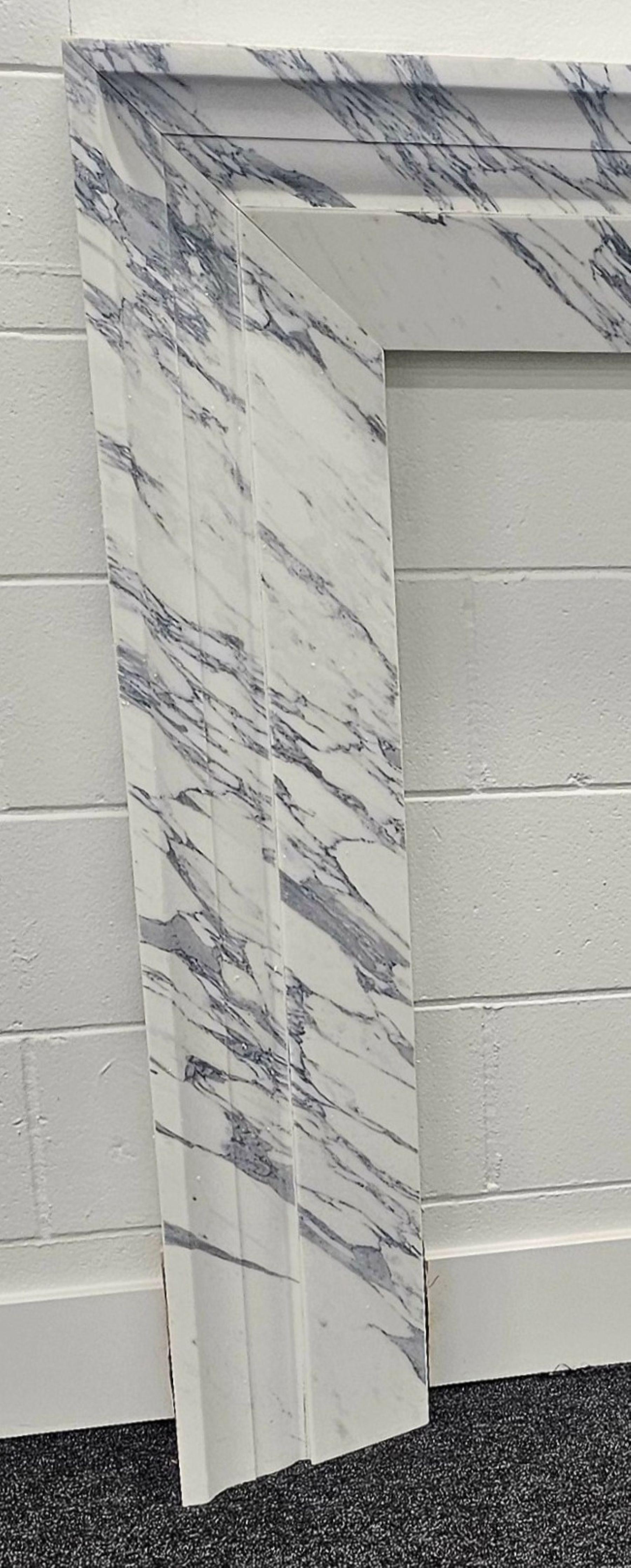 Cette cheminée moderne, en superbe marbre Arabescato Corchia, serait parfaite dans presque n'importe quelle pièce.  Il conviendrait parfaitement à un décor contemporain ou plus transitionnel.  Les différentes couches de moulage s'étendent sur toute